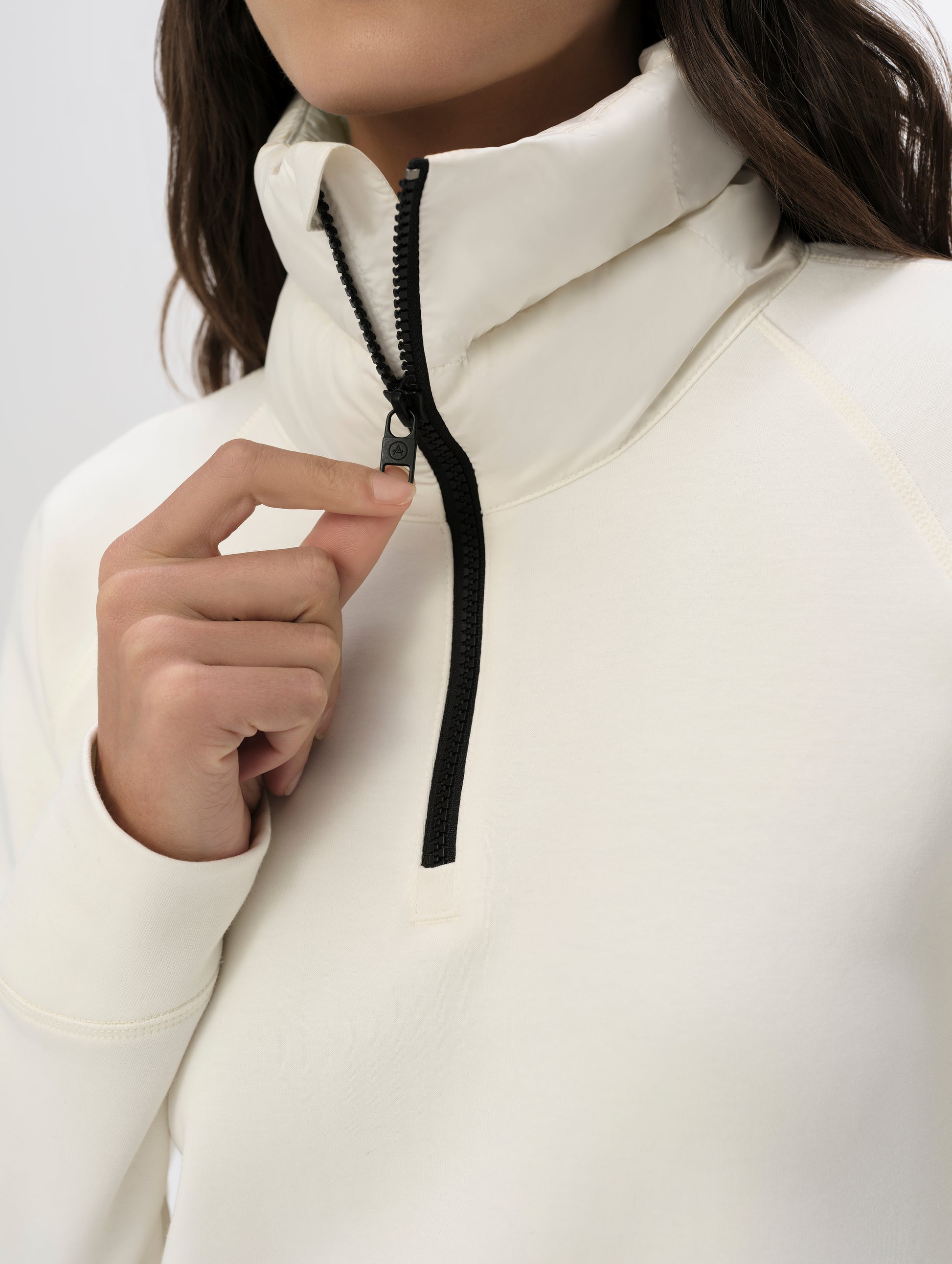 Closeup view of the half-length center-front zipper on the Align Half-Zip Pullover in Winter White from AETHER Apparel.