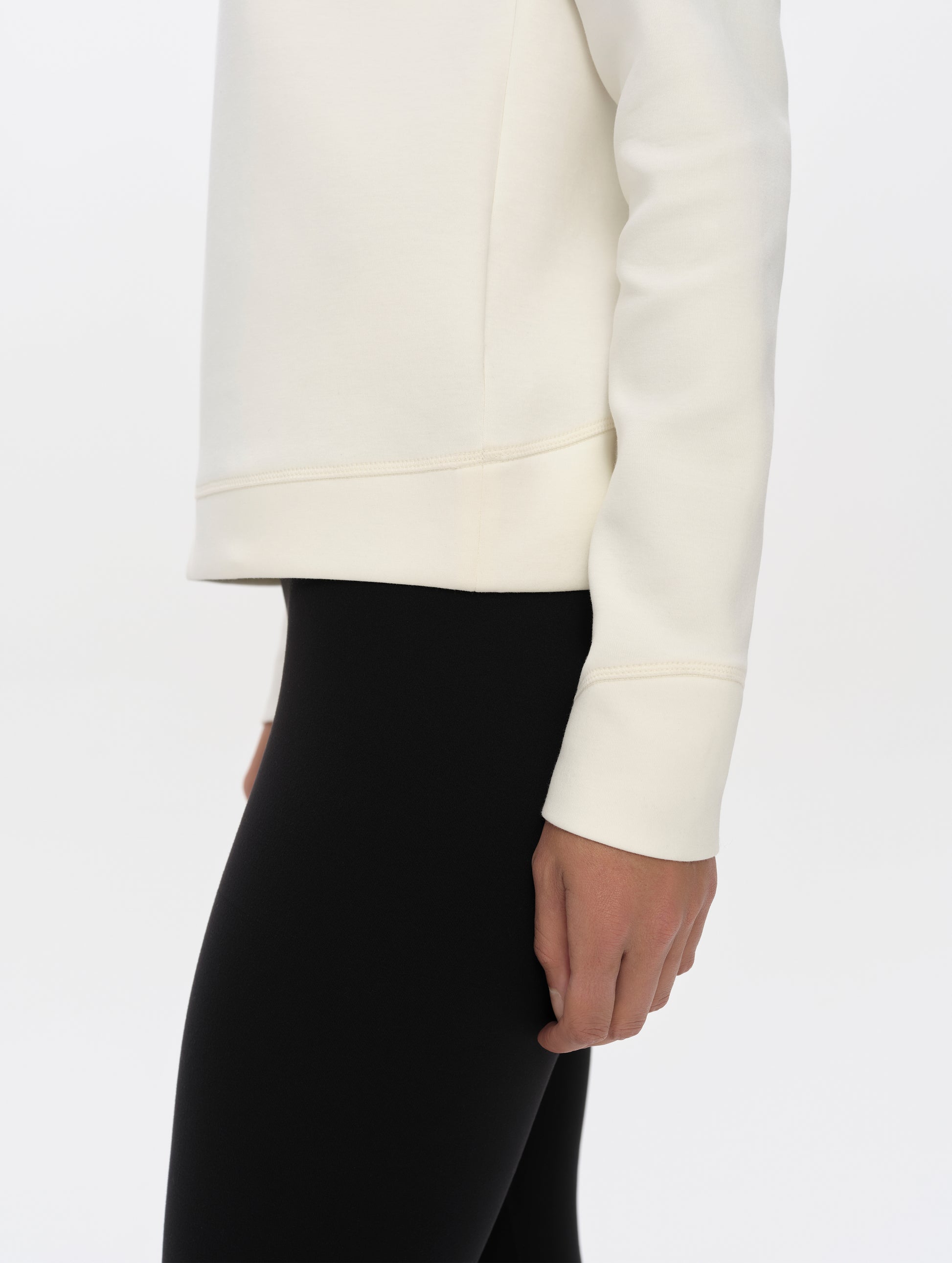 Closeup detailed side profile view of the hem, cuffs, and hand pockets on the Align Half-Zip Pullover in Winter White from AETHER Apparel.