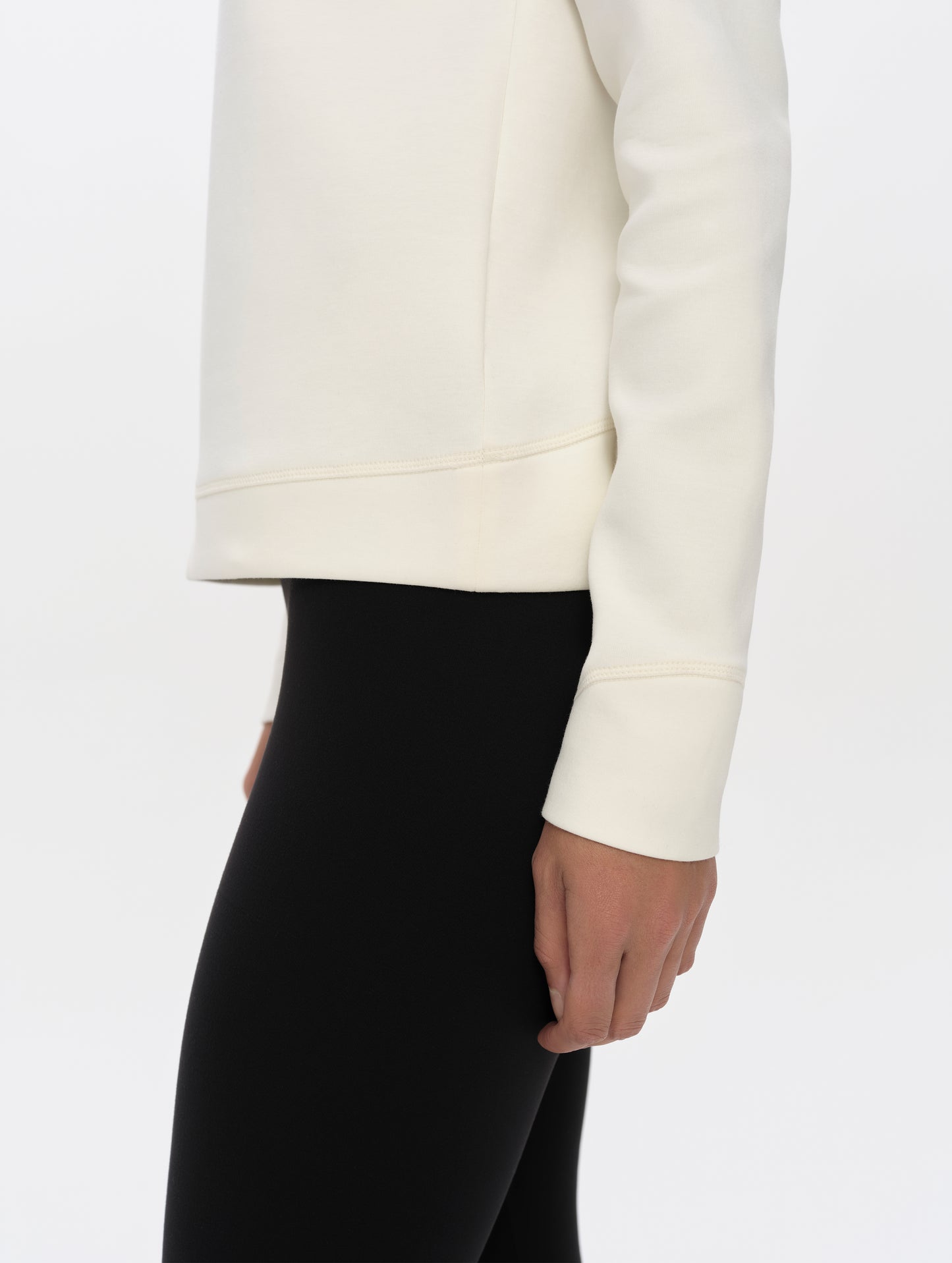 Closeup detailed side profile view of the hem, cuffs, and hand pockets on the Align Half-Zip Pullover in Winter White from AETHER Apparel.