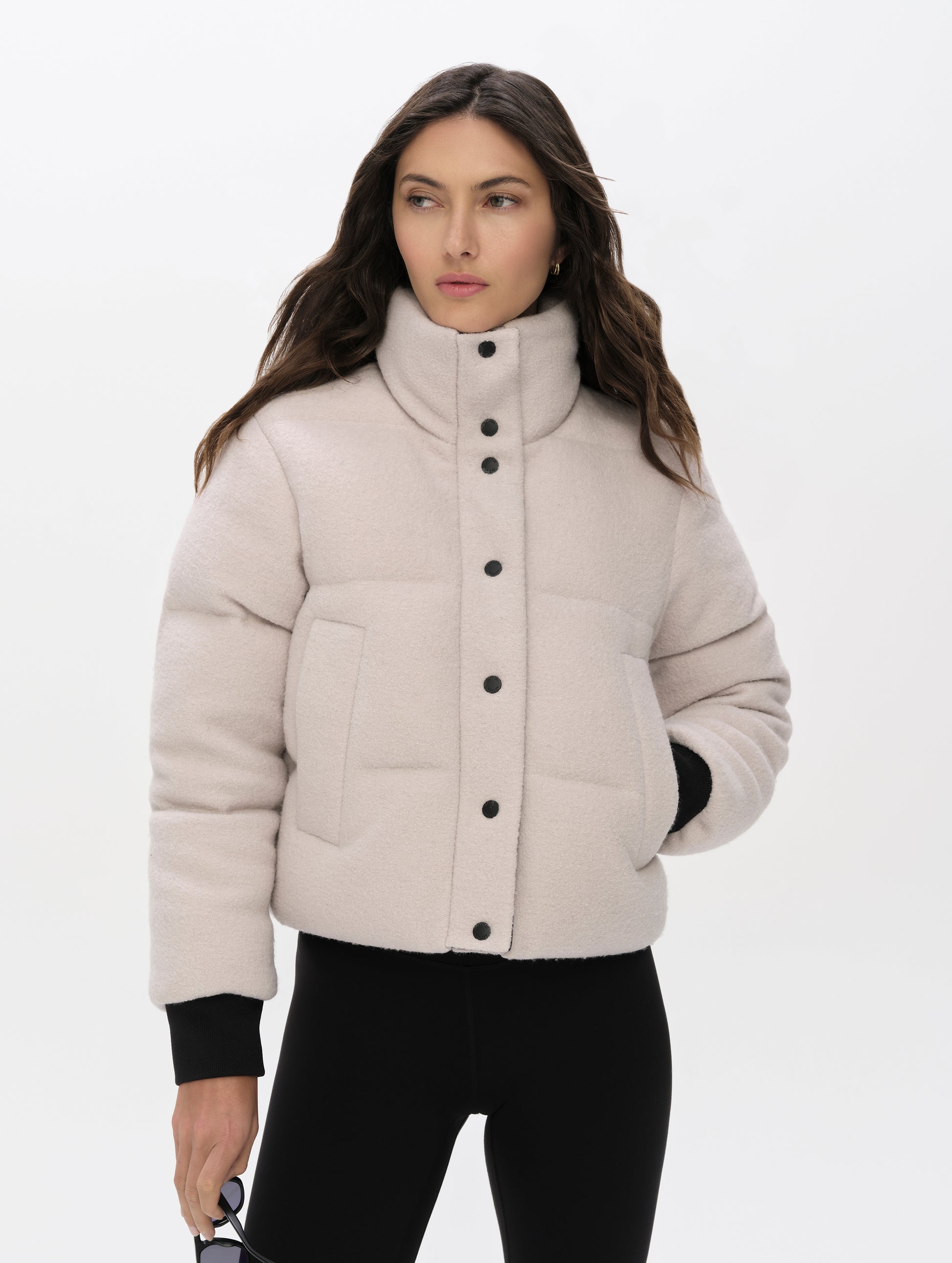 Front upper-body view of woman wearing the Aura Puffer Jacket Wool in Bone white from AETHER Apparel.