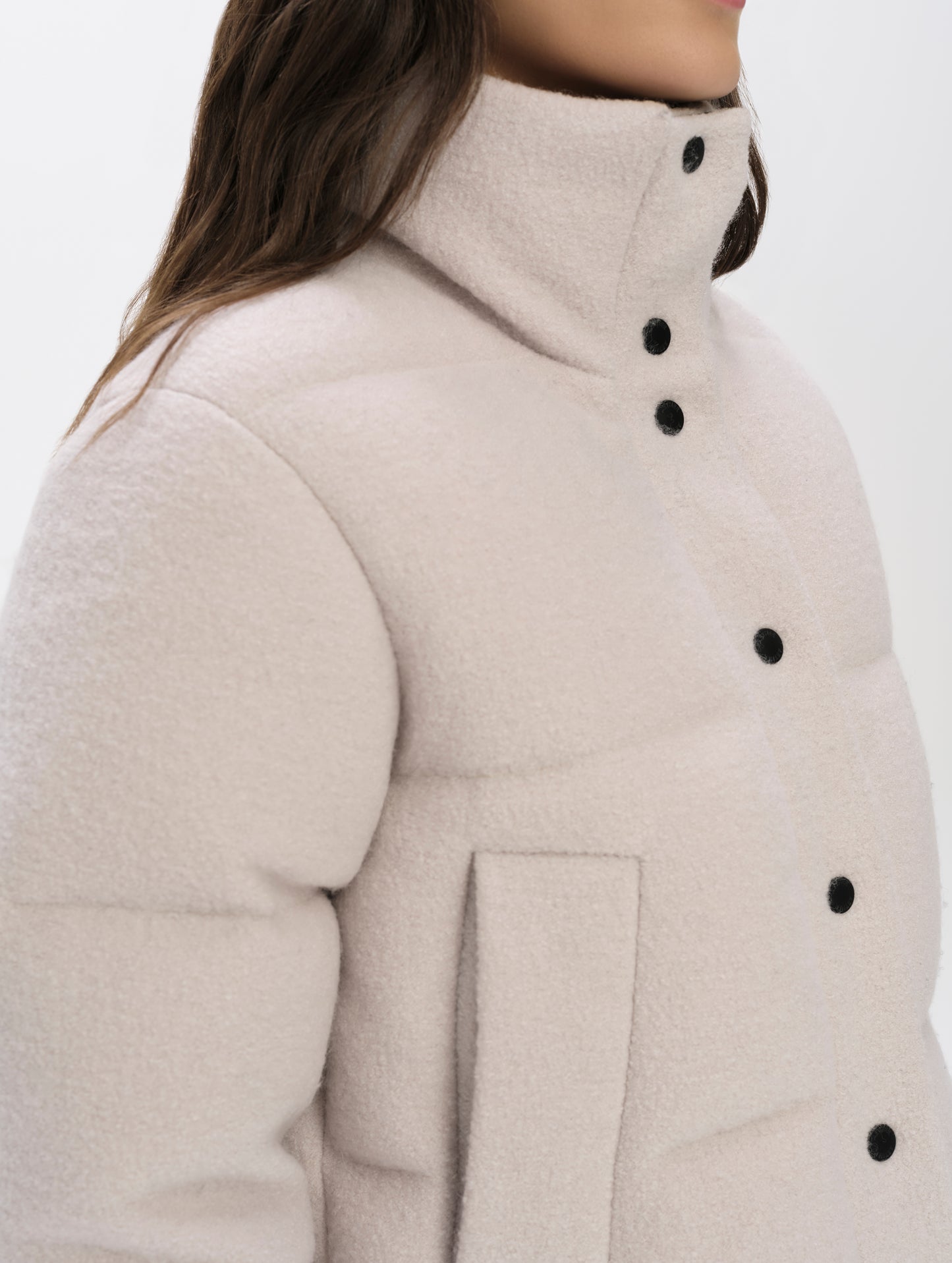 Closeup detailed view of the collar, hand pockets, and main center-front closure on the Aura Puffer Jacket Wool in Bone white from AETHER Apparel.