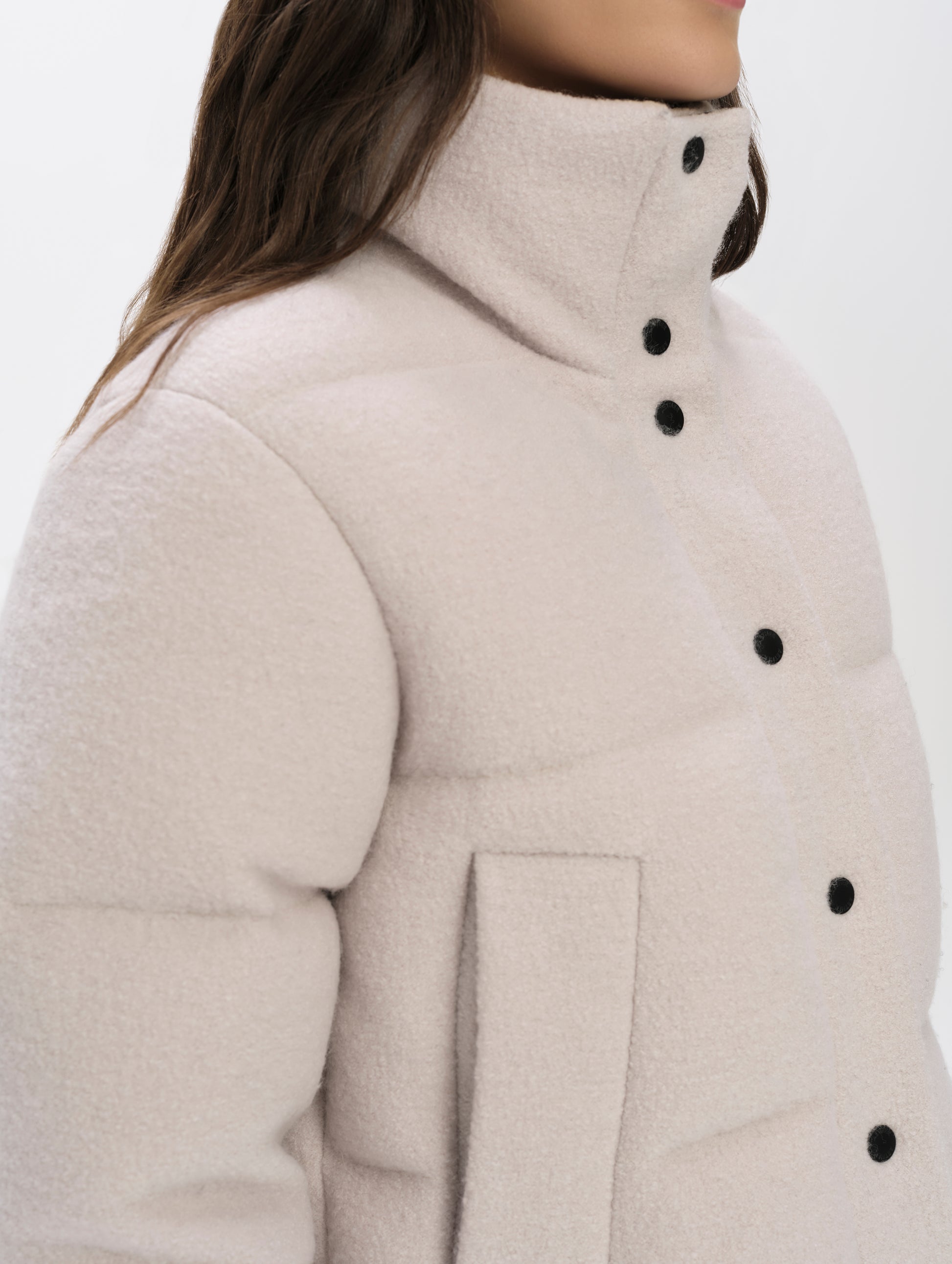 Closeup detailed view of the collar, hand pockets, and main center-front closure on the Aura Puffer Jacket Wool in Bone white from AETHER Apparel.