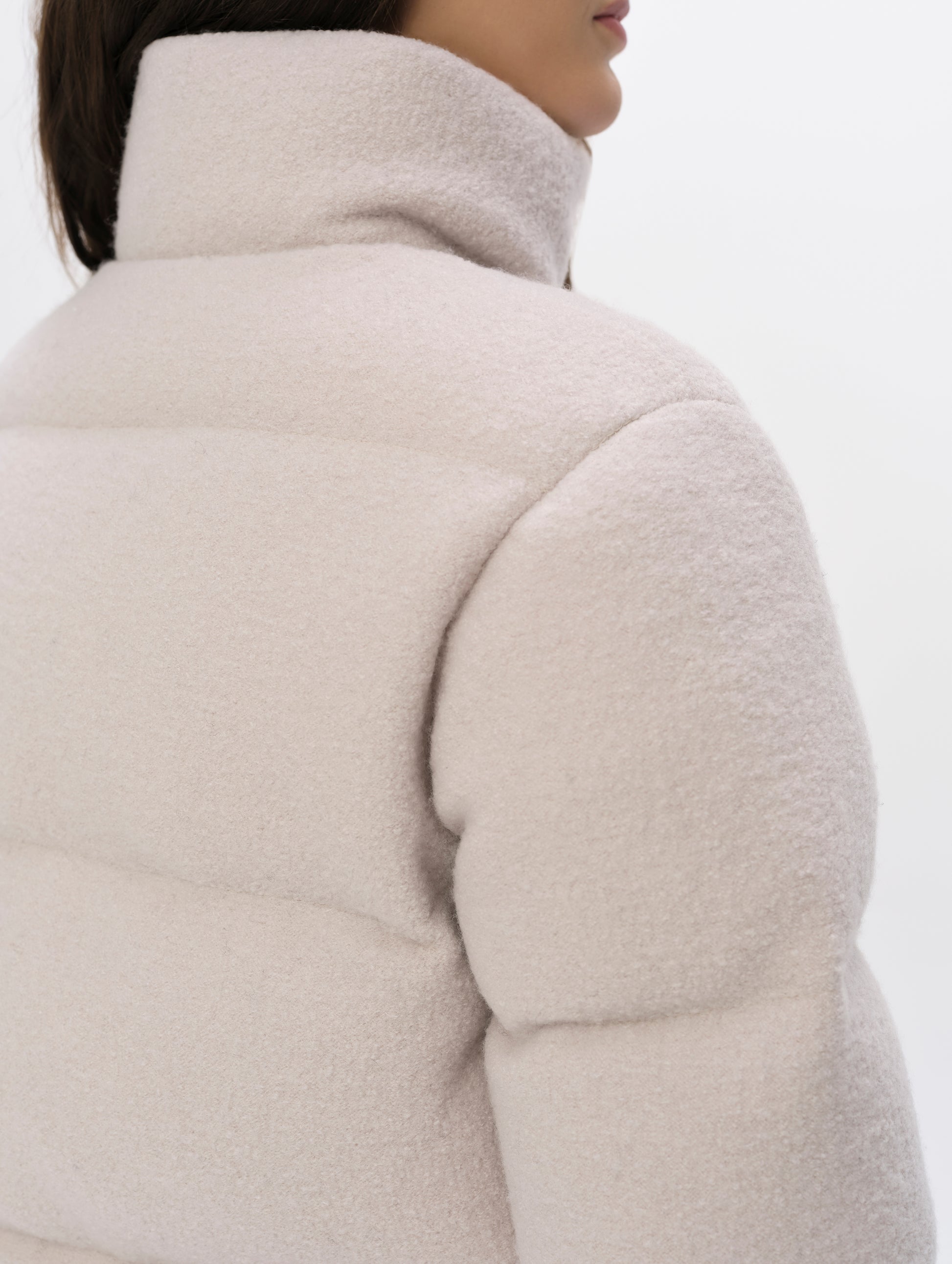 Closeup detailed view of the collar and shoulders on the Aura Puffer Jacket Wool in Bone white from AETHER Apparel.