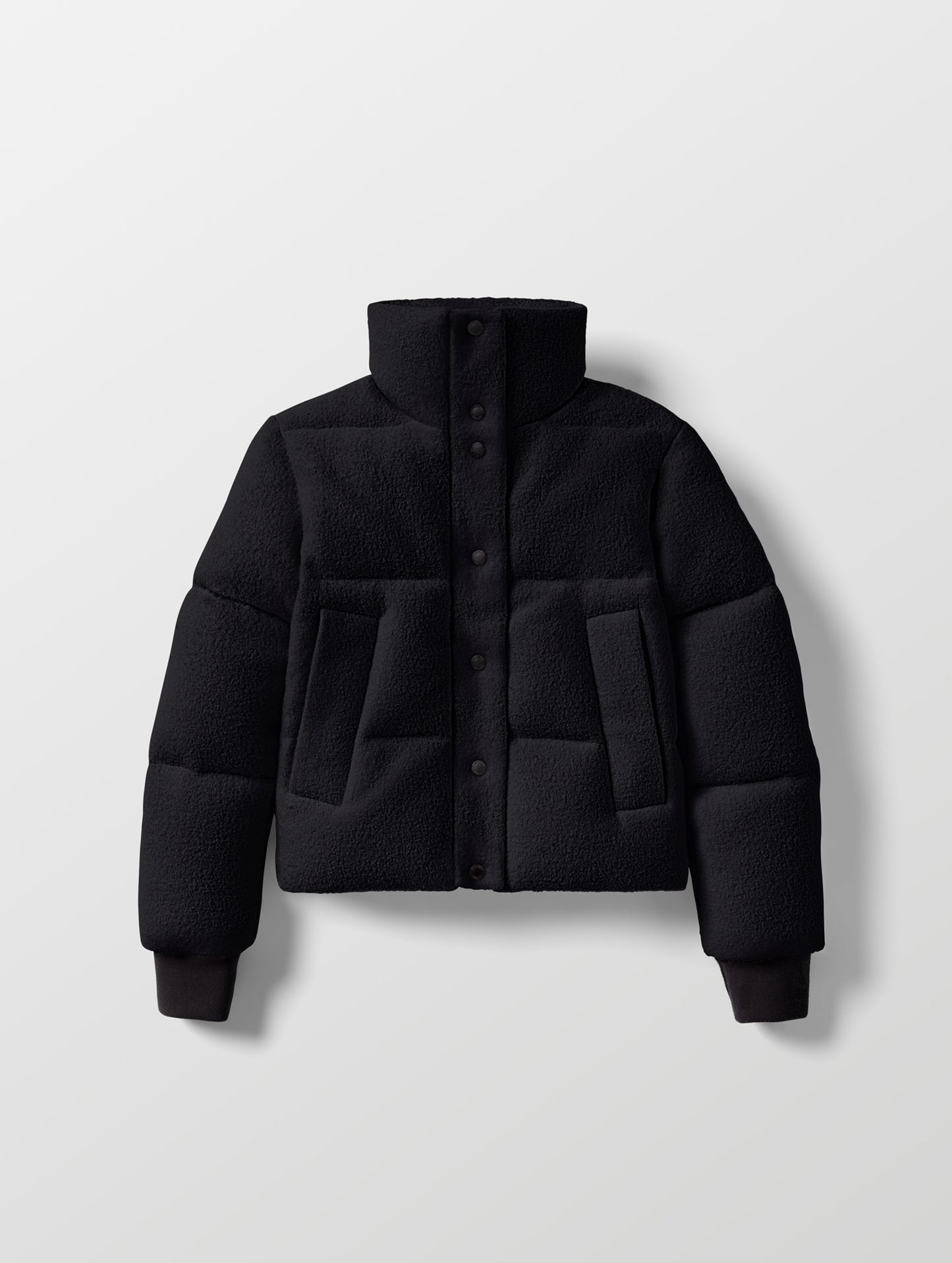 Flat lay of the Aura Puffer Jacket Wool in Onyx Black from AETHER Apparel.