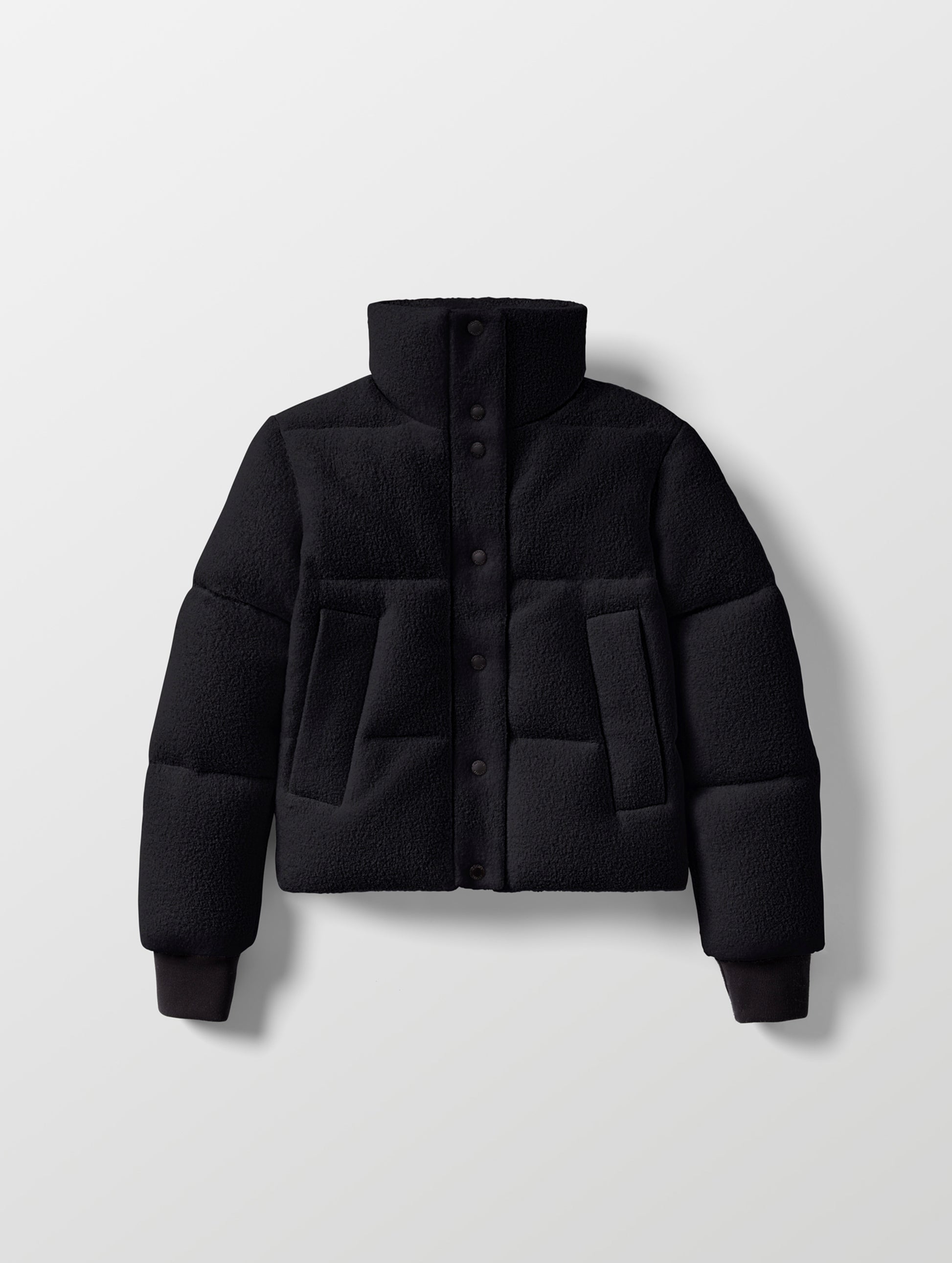 Flat lay of the Aura Puffer Jacket Wool in Onyx Black from AETHER Apparel.