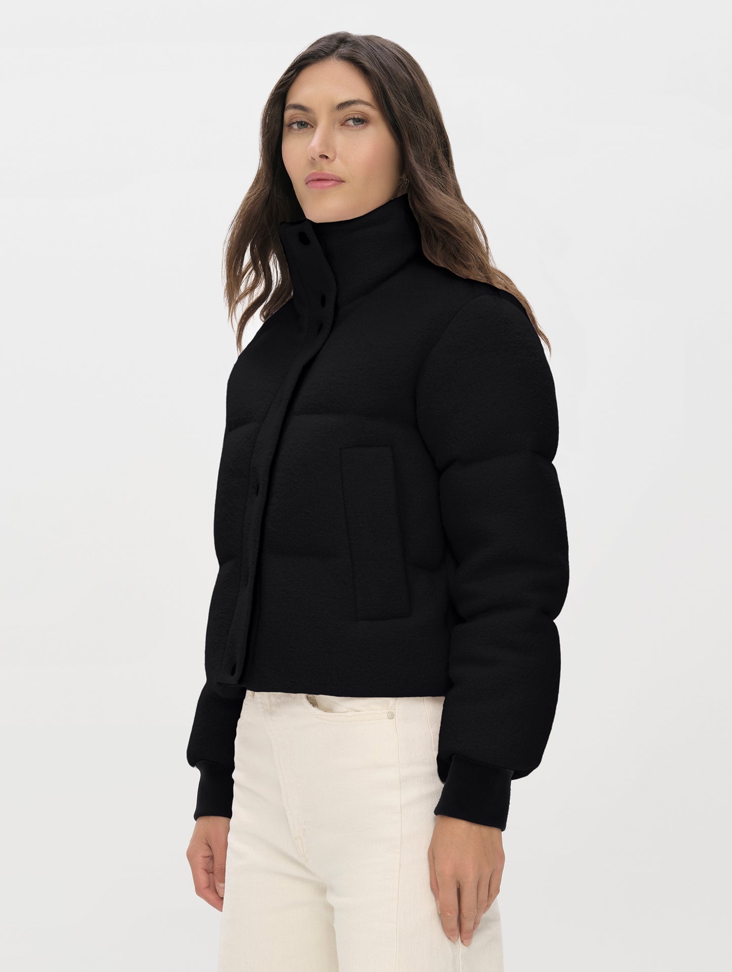 Front angled upper-body view of woman wearing the Aura Puffer Jacket Wool in Onyx Black from AETHER Apparel.