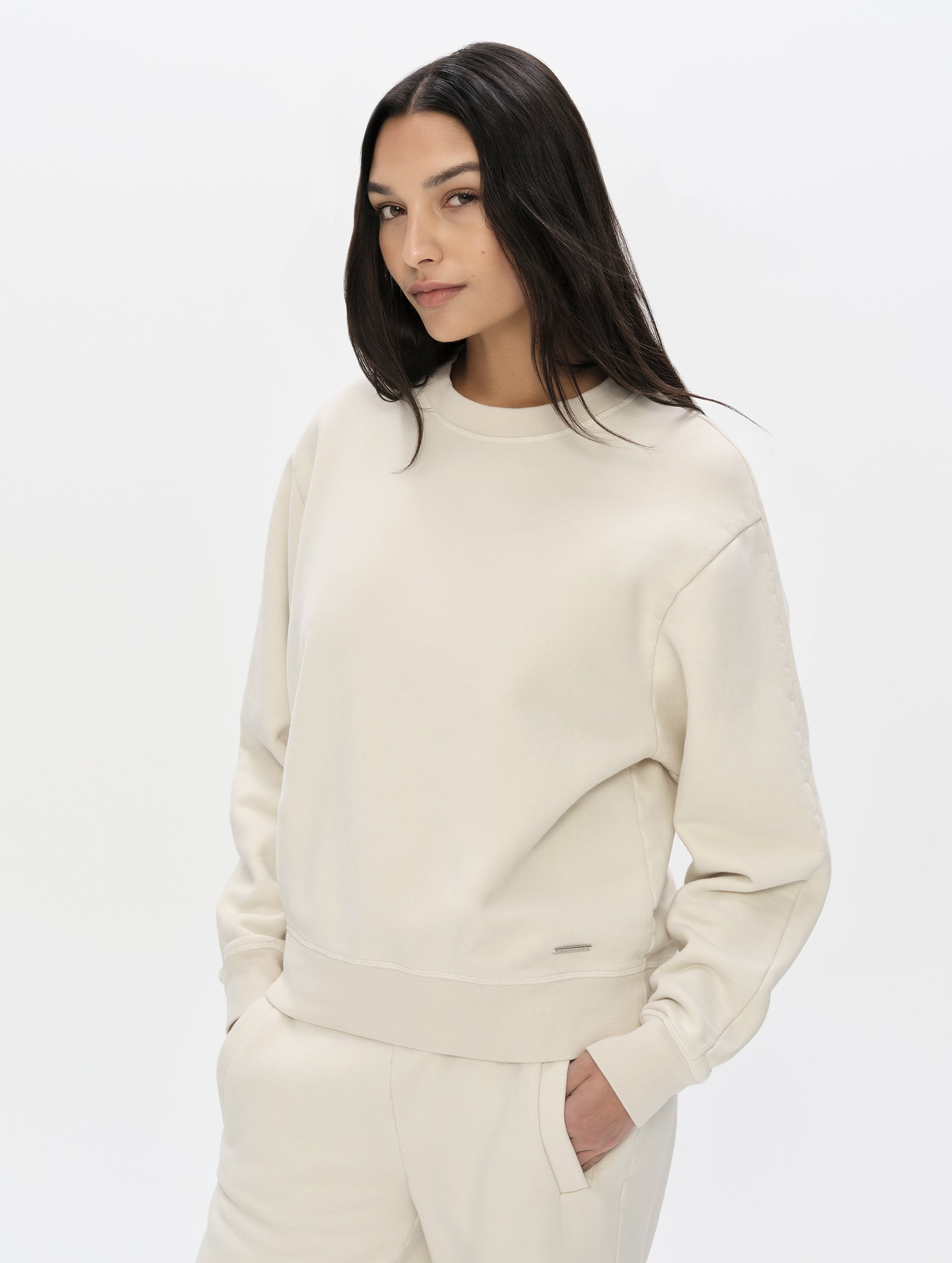 Front, upper-body view of woman wearing the Ayla Crewneck Sweatshirt in Bone from AETHER Apparel.