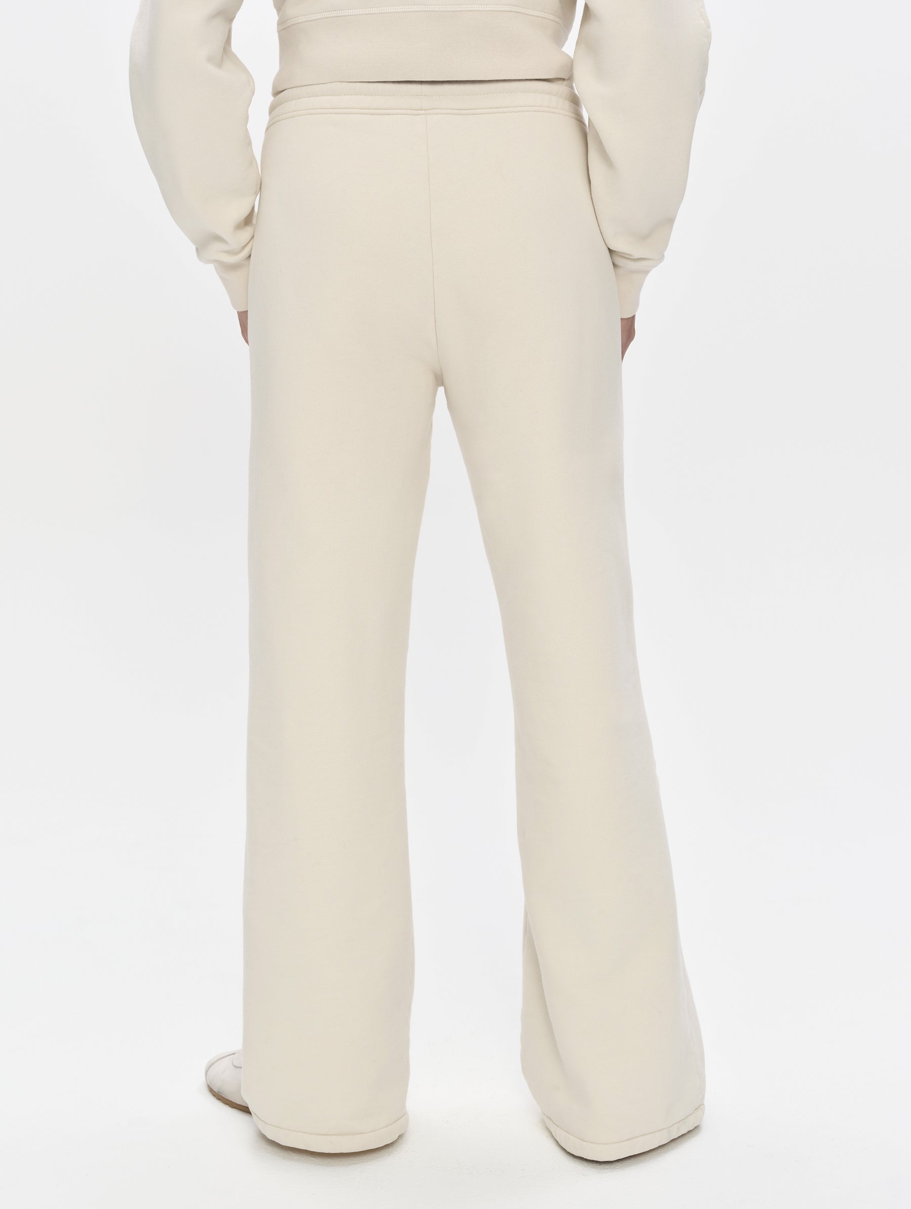 Rear, lower-body view of woman wearing the Ayla Wide-Leg Sweatpant in Bone from AETHER Apparel.