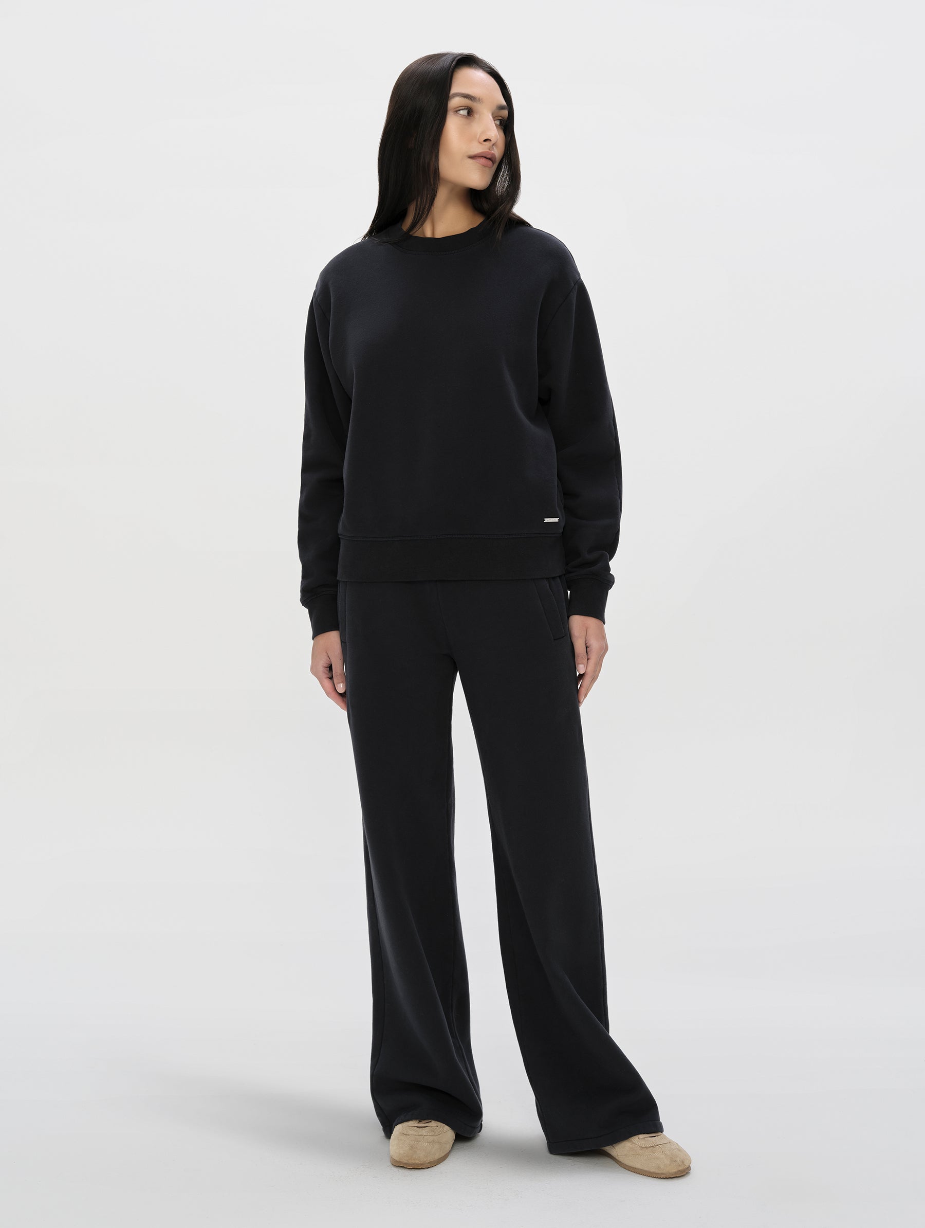 Front, full-body view of woman wearing the Ayla Wide-Leg Sweatpant in Onyx Black from AETHER Apparel.