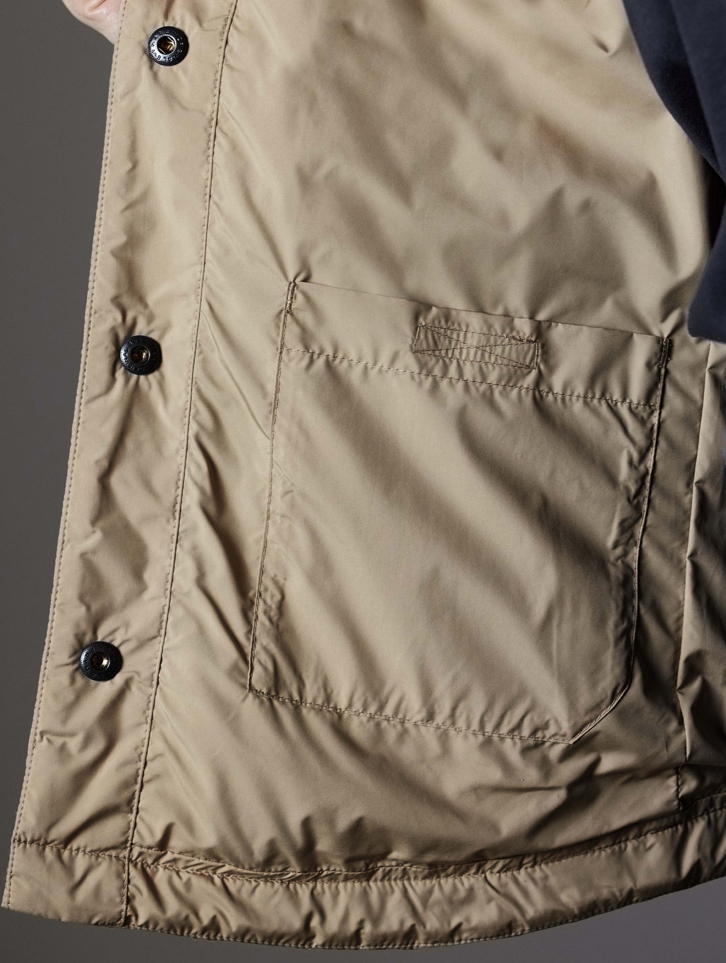 Closeup detailed view of the interior pocket on the Bardo Shirt Jacket in Chinchilla Brown from AETHER Apparel.Closeup detailed view of the collar and top snap buttons on the Bardo Shirt Jacket in Chinchilla Brown from AETHER Apparel.