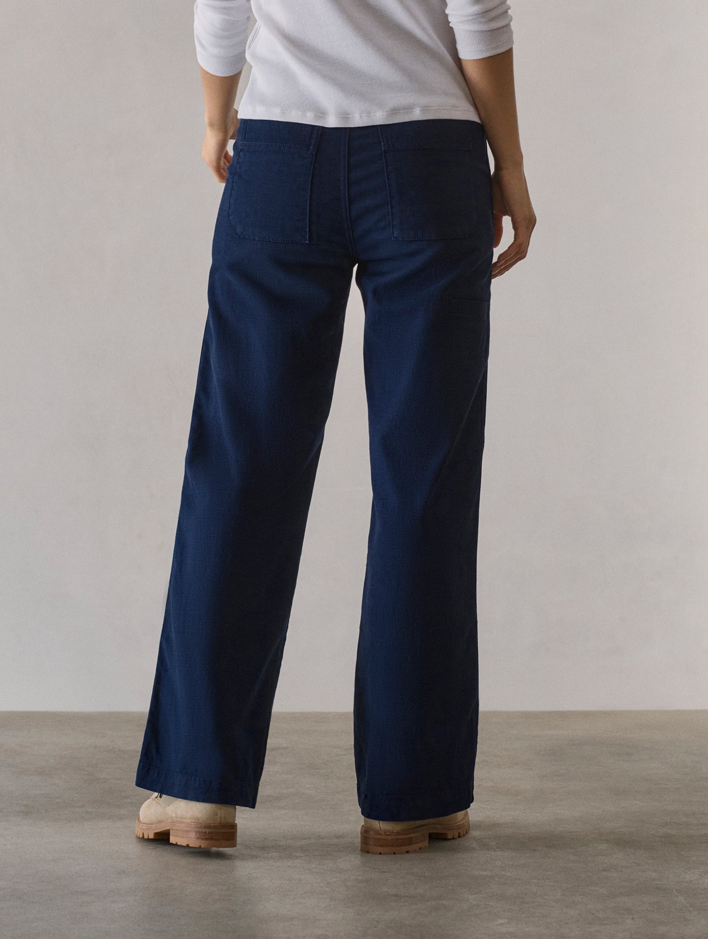 Rear lower body view of woman wearing Bella Travel Pant in Nordic Navy from AETHER Apparel.