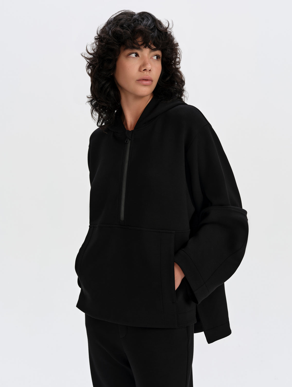 Front 3/4 upper-body view of woman wearing the Blaire Premium Hoodie in Onyx Black from AETHER Apparel.