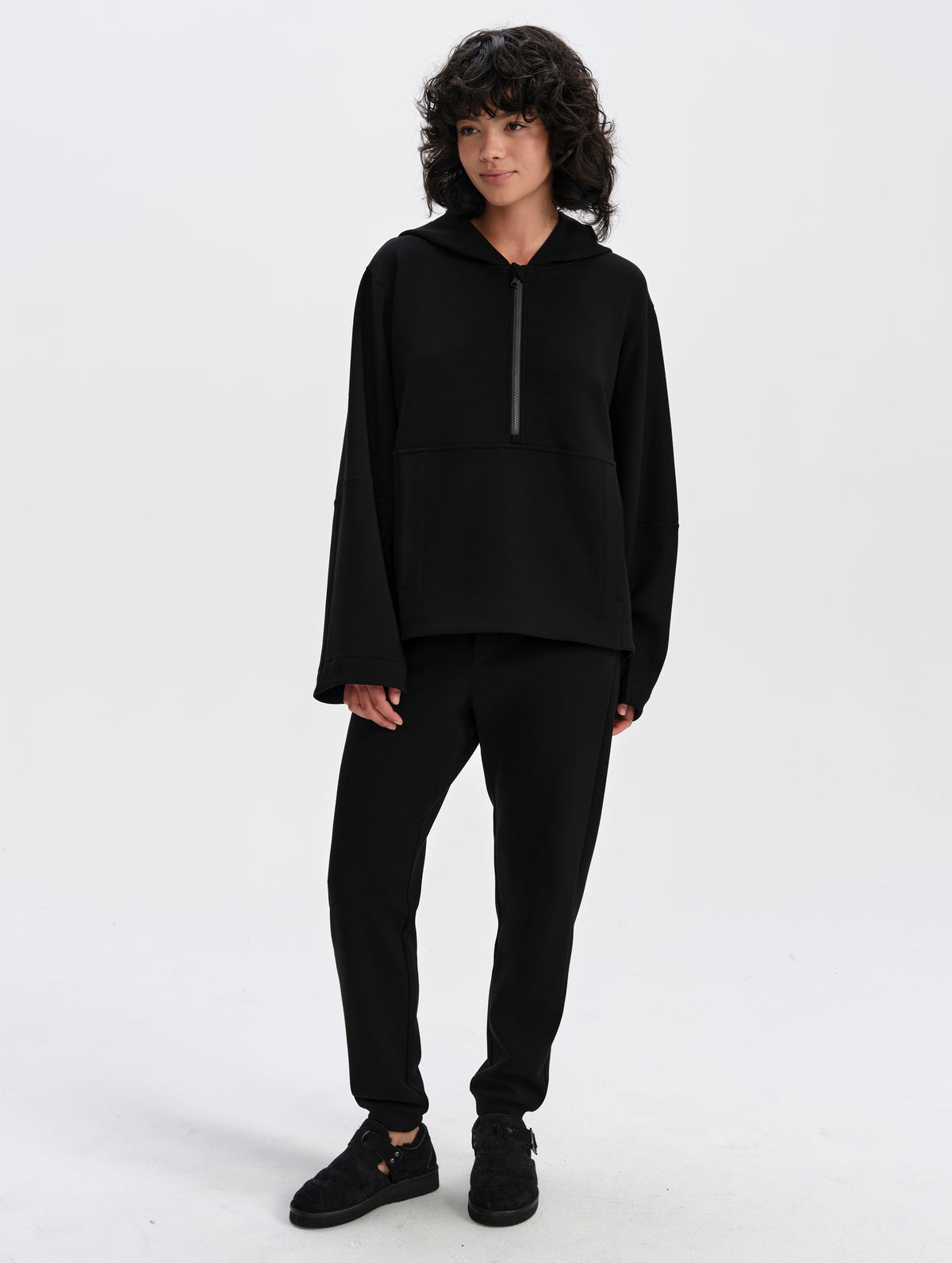 Front full-body view of woman wearing the Blaire Premium Hoodie in Onyx Black from AETHER Apparel.