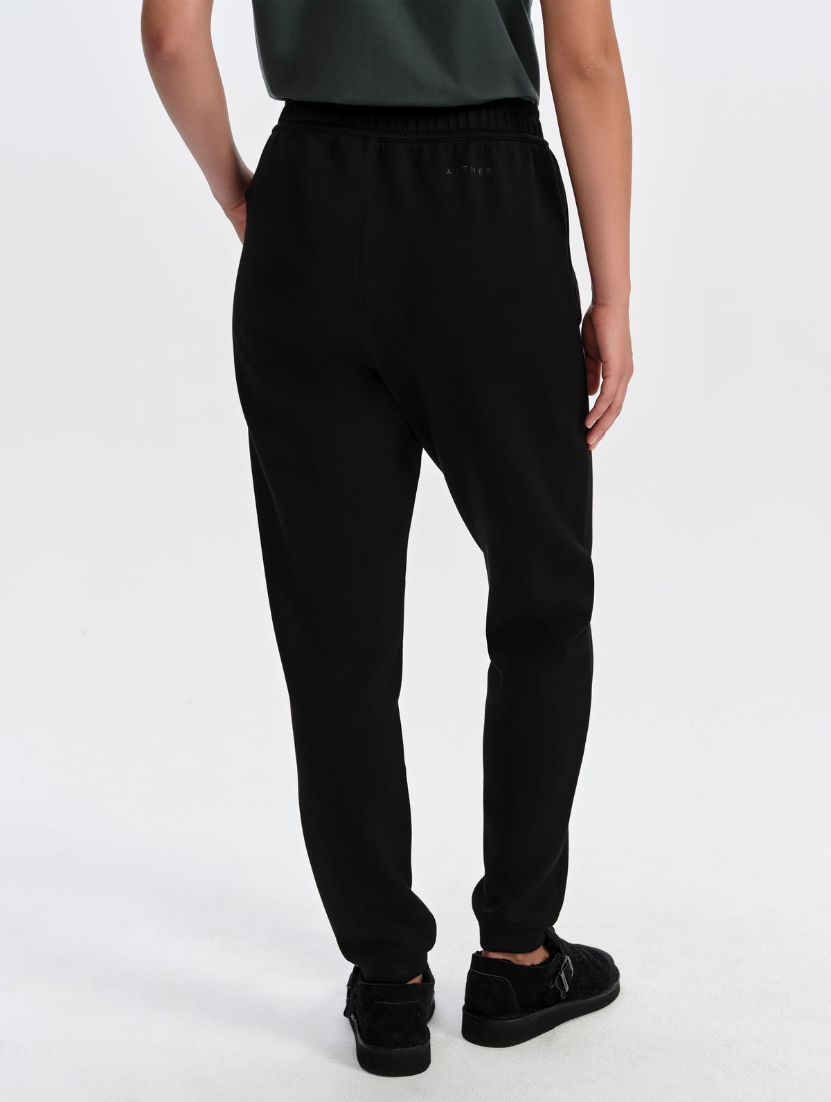 Rear lower-body view of woman wearing the Blaire Premium Sweatpant in Onyx Black from AETHER Apparel.