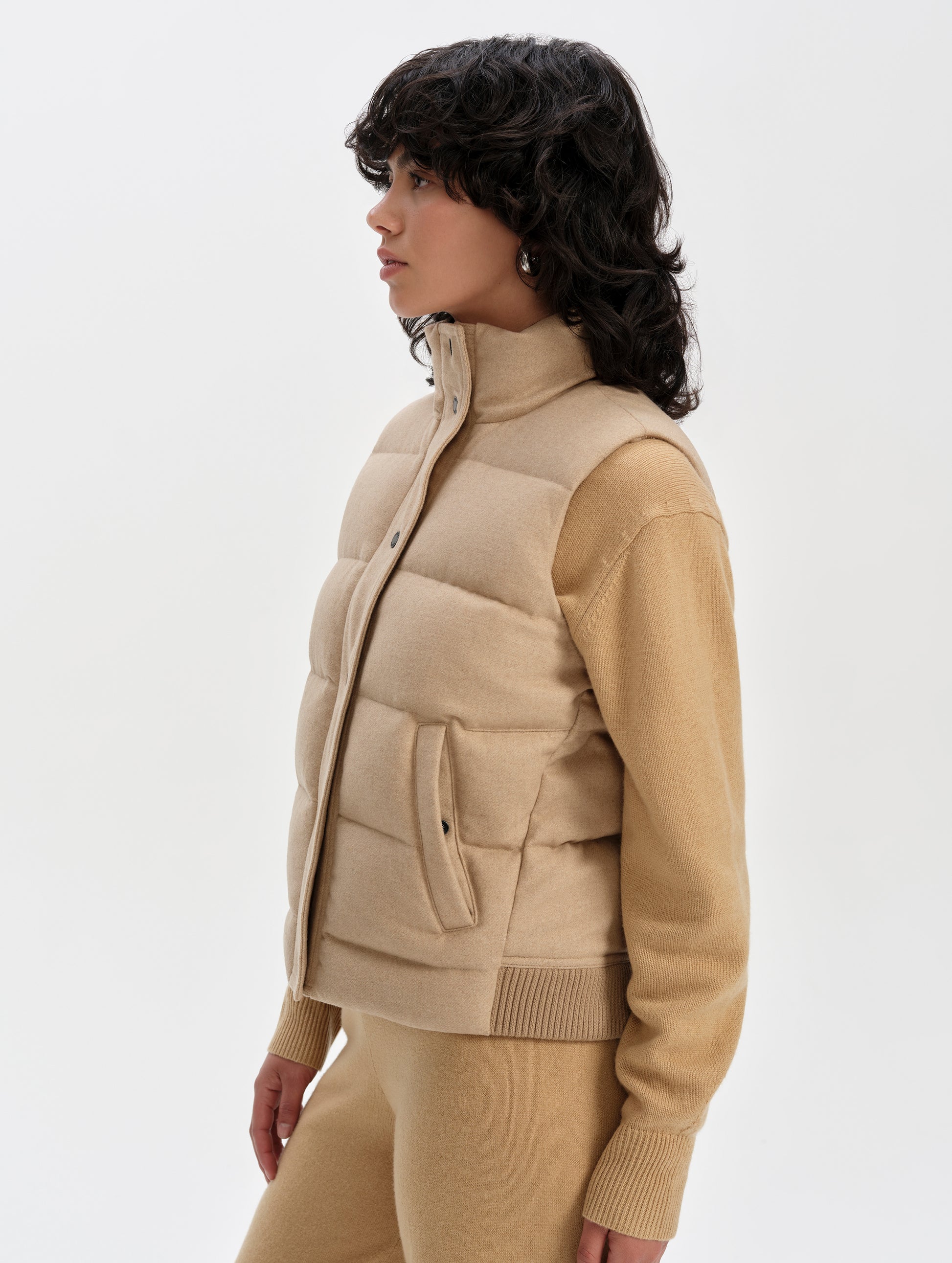 Side profile upper-body view of woman wearing Channing Vest 2.0 in Latte Brown from AETHER Apparel.