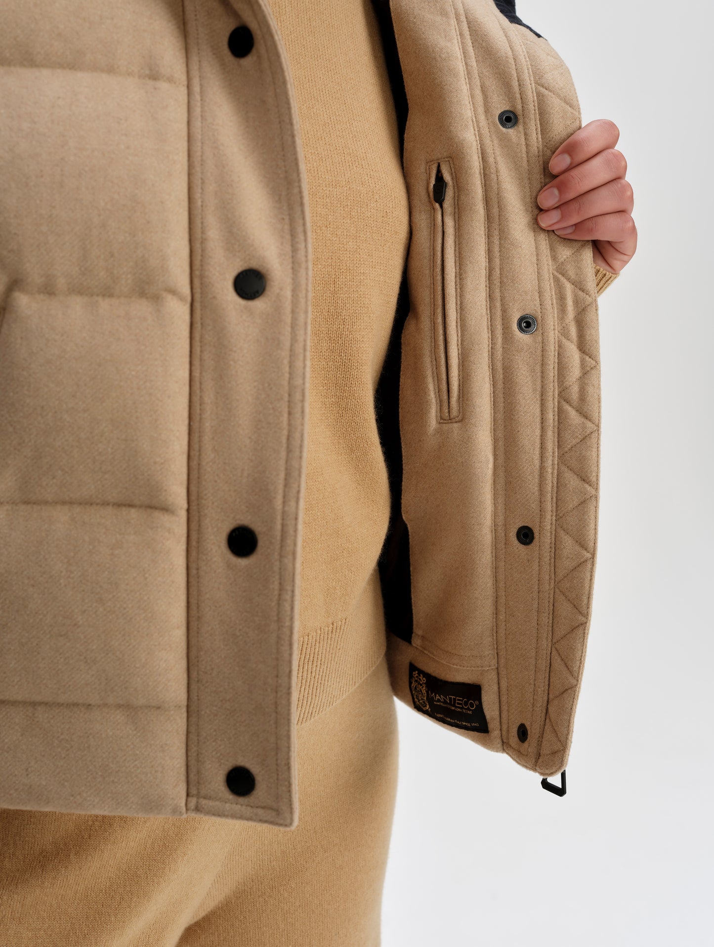 Closeup detailed view of the zig-zag stitching and the interior zippered pocket on the Channing Vest 2.0 in Latte Brown from AETHER Apparel.