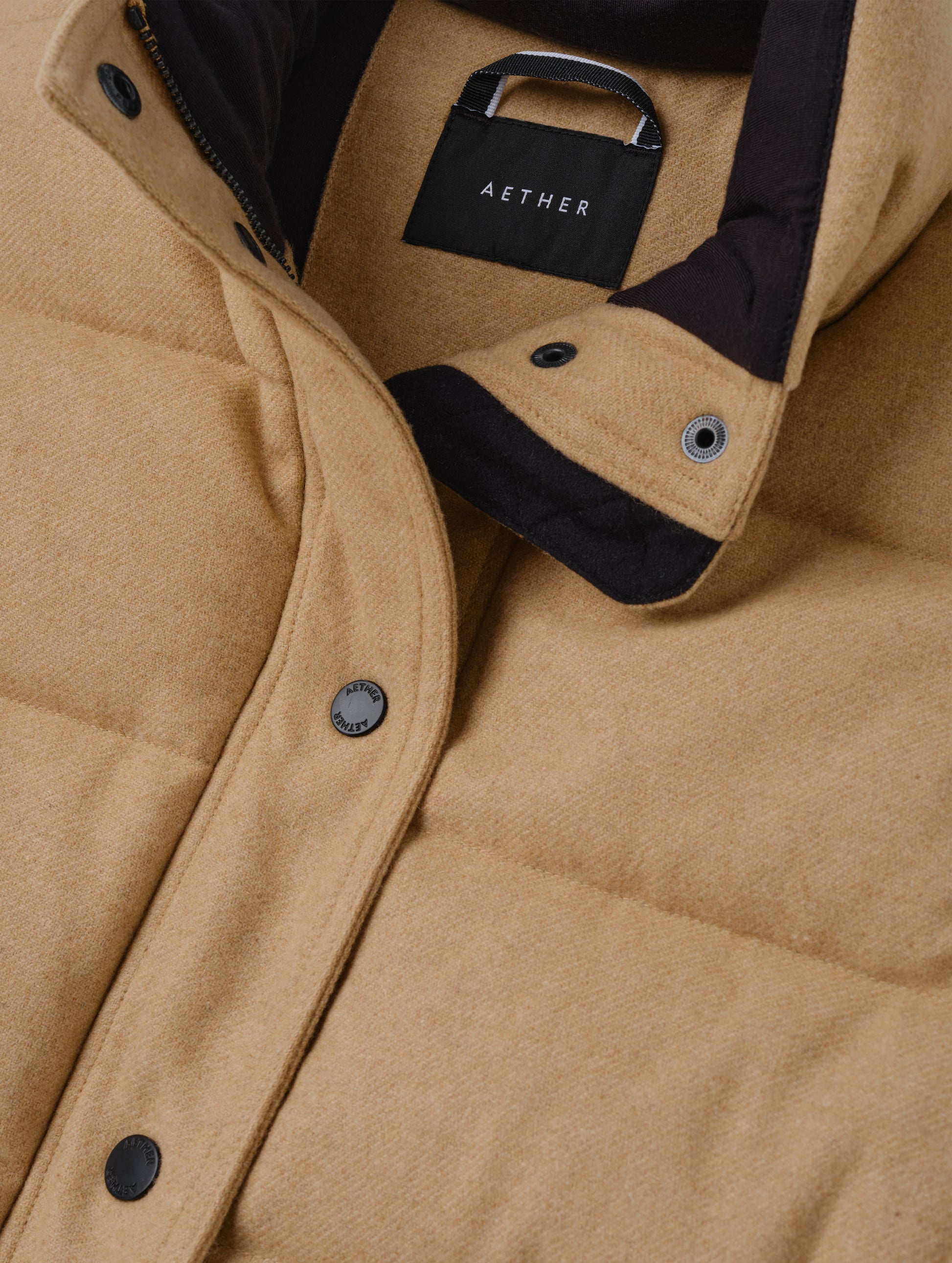 Closeup detailed view of the main center-front snap closure on the Channing Vest 2.0 in Latte Brown from AETHER Apparel.