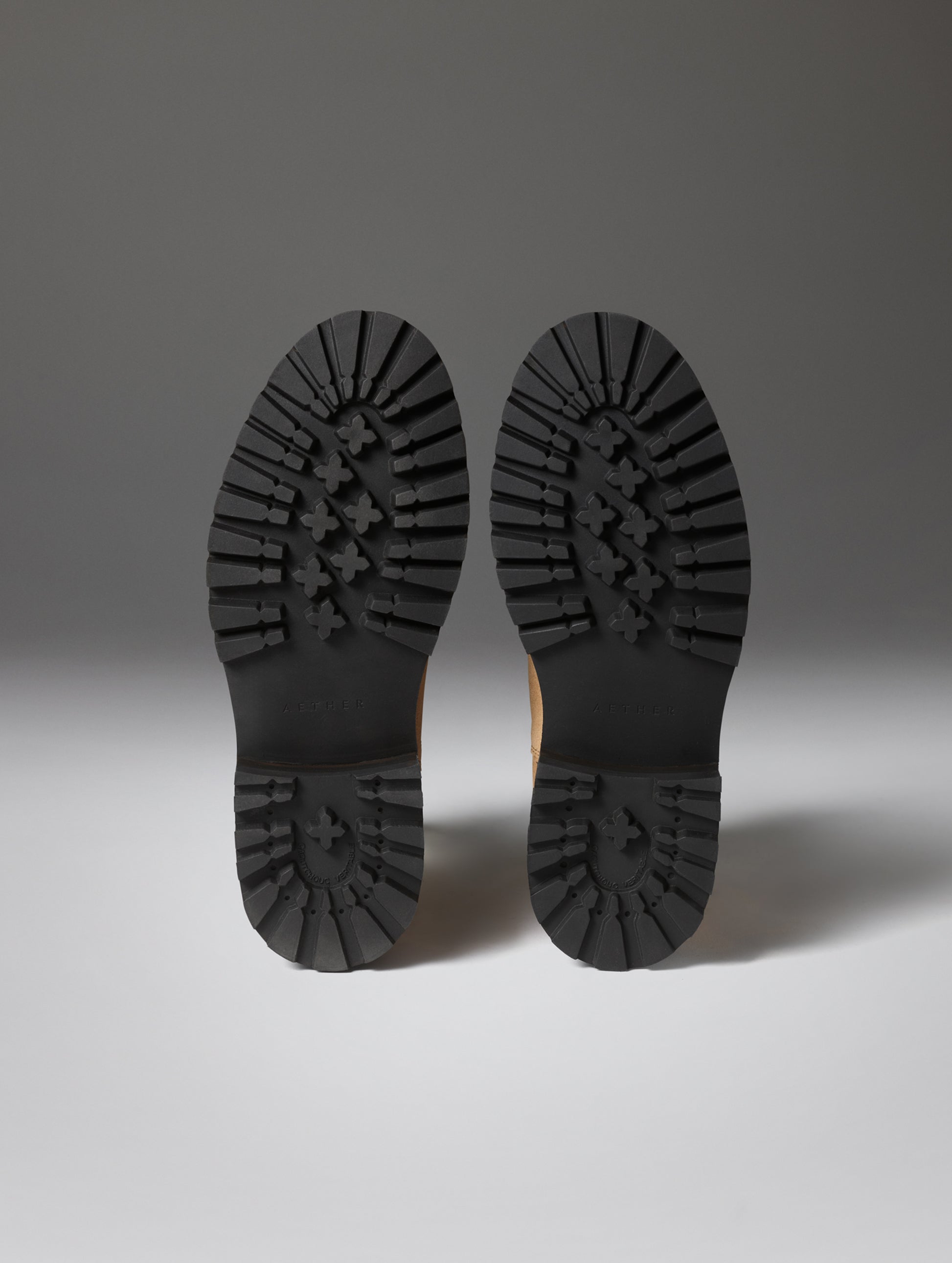 Bottom view of the deep-lug rubber outsoles on the Crosby Boot in Dark Clay from AETHER Apparel.
