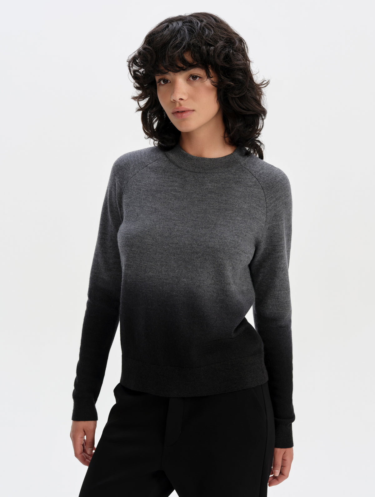 Front upper-body view of woman wearing the Dash Ombre Sweater in Charcoal Grey from AETHER Apparel.