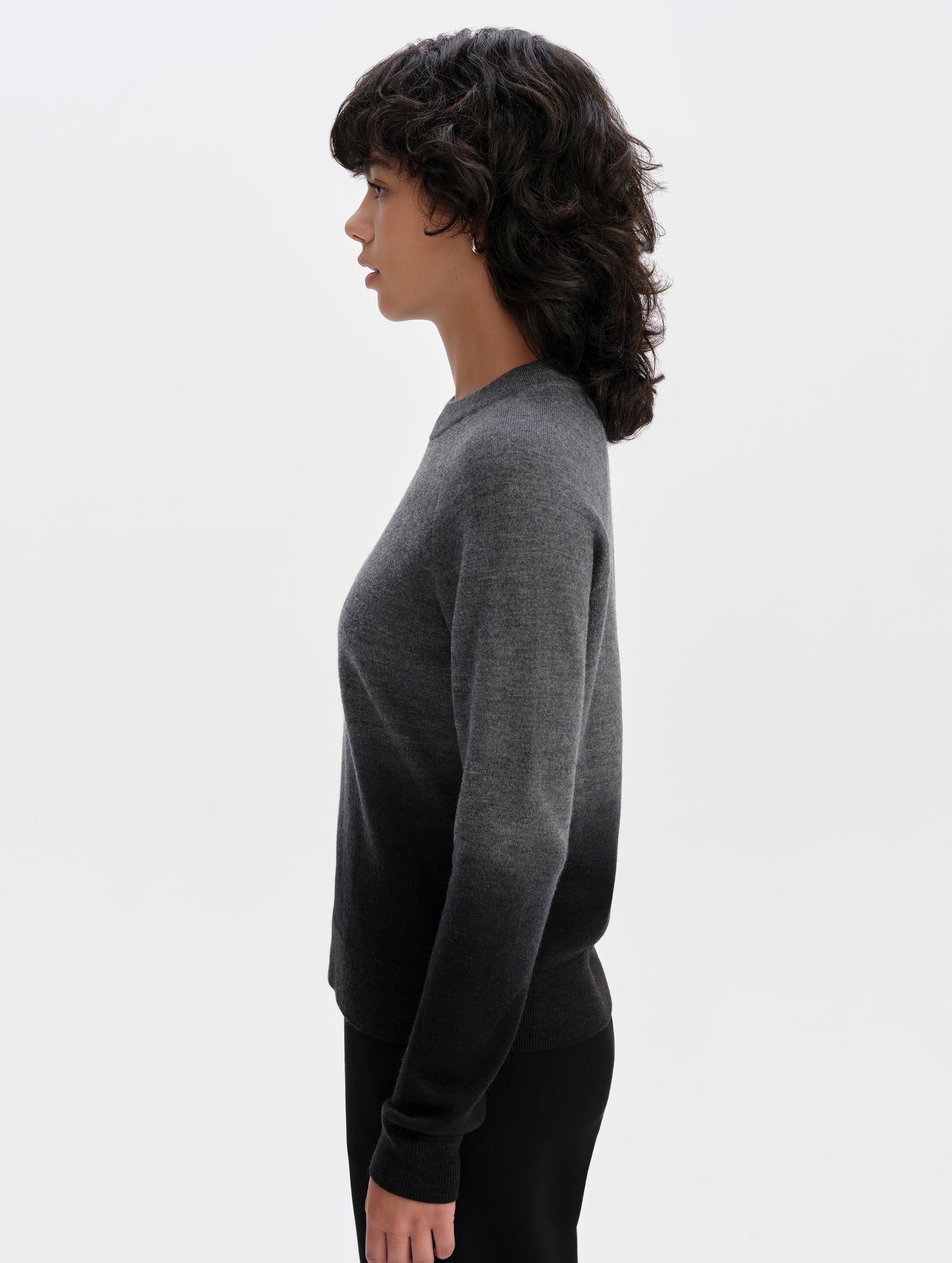 Side profile upper-body view of woman wearing the Dash Ombre Sweater in Charcoal Grey from AETHER Apparel.