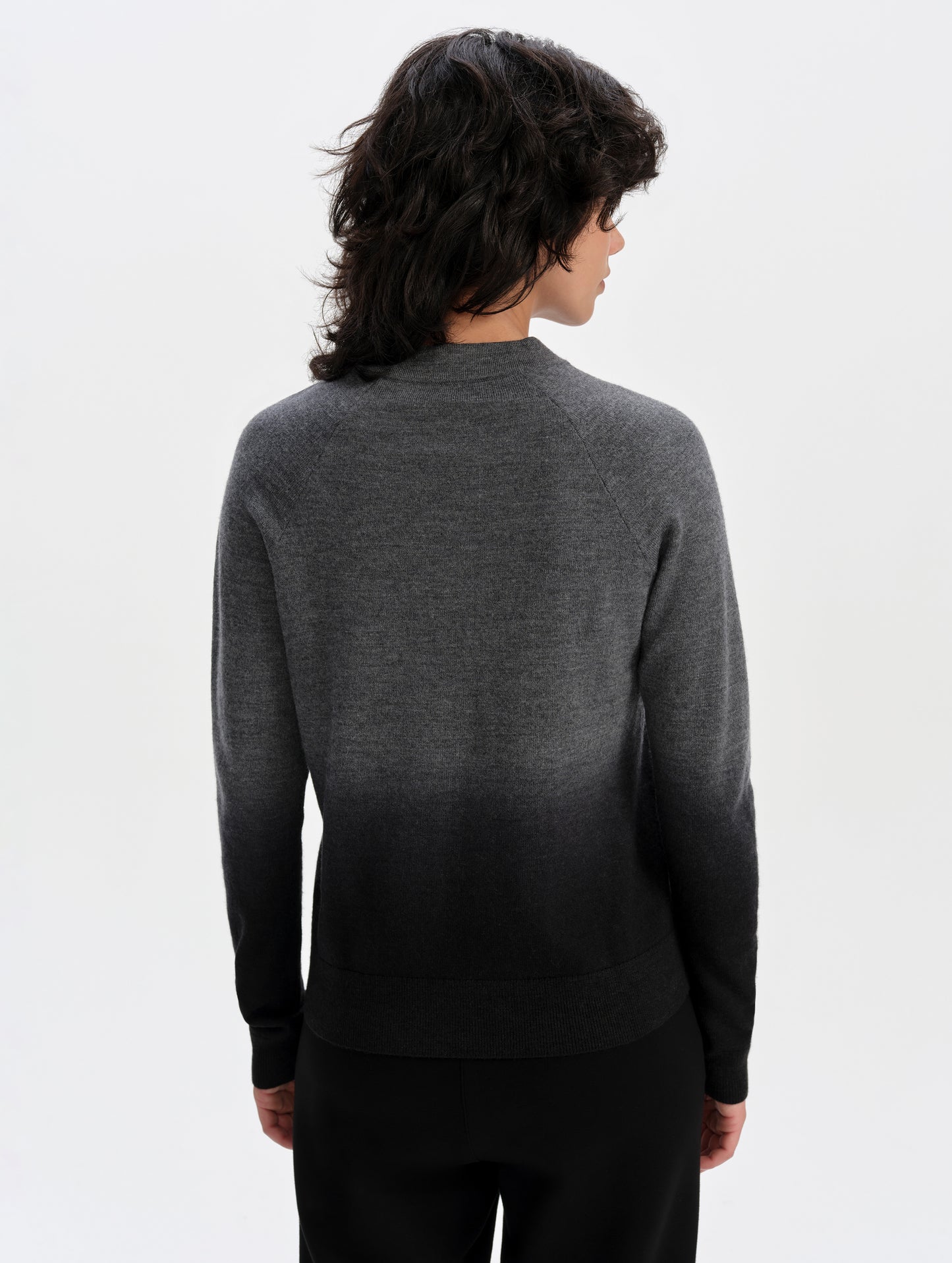 Rear upper-body view of woman wearing the Dash Ombre Sweater in Charcoal Grey from AETHER Apparel.