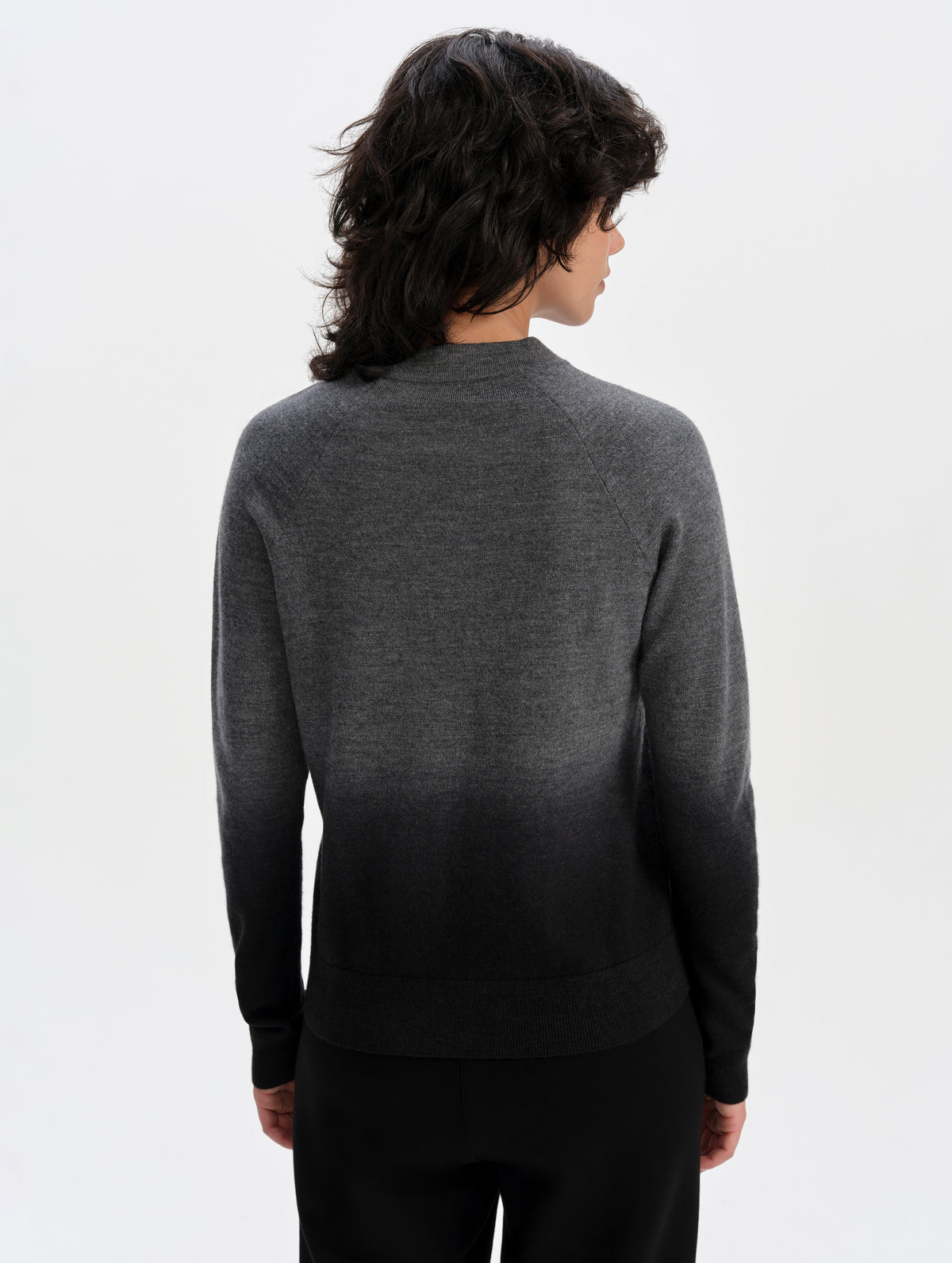 Rear upper-body view of woman wearing the Dash Ombre Sweater in Charcoal Grey from AETHER Apparel.