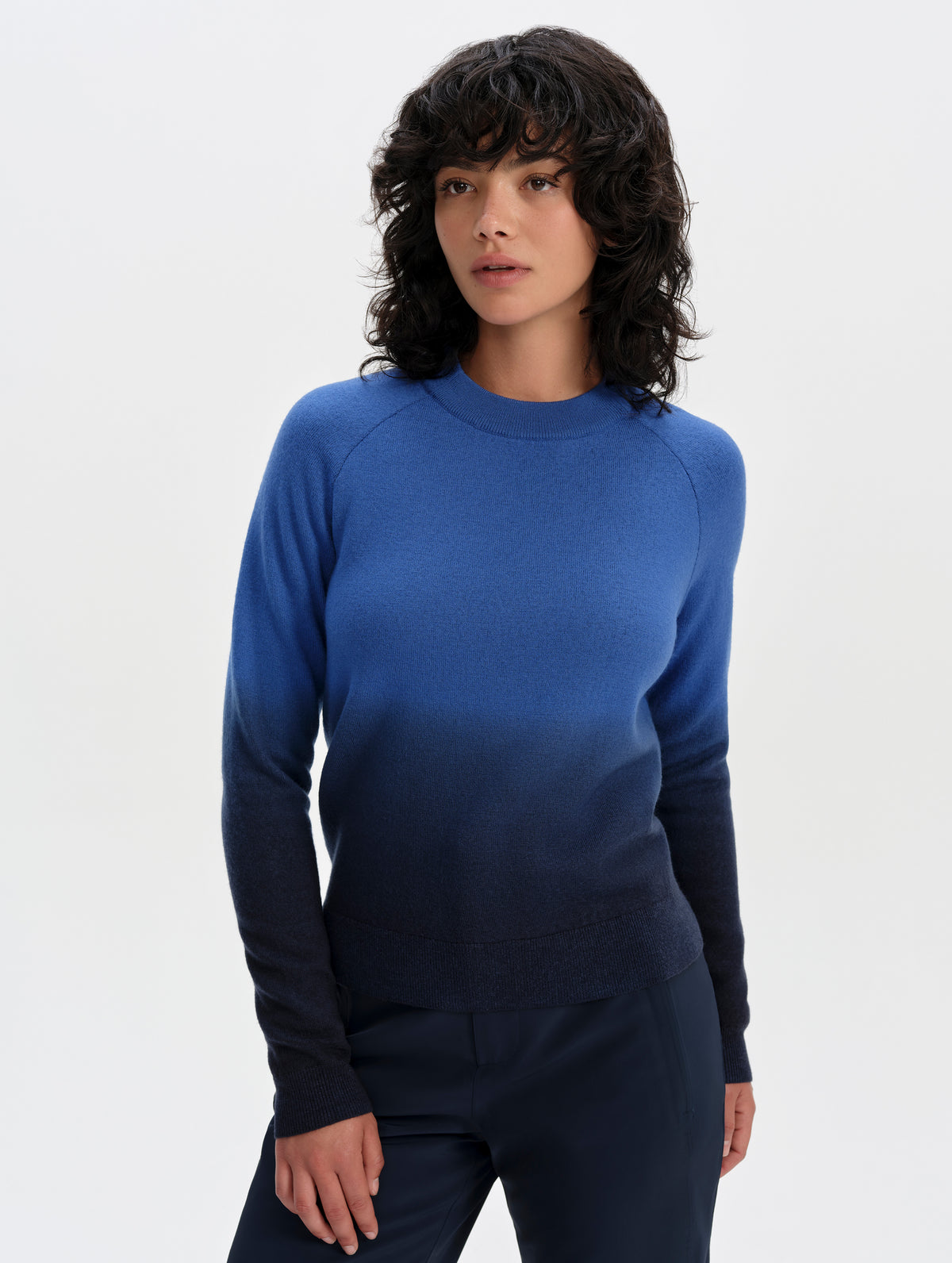 Front upper-body view of woman wearing the Dash Ombre Sweater in Galaxy Blue from AETHER Apparel.