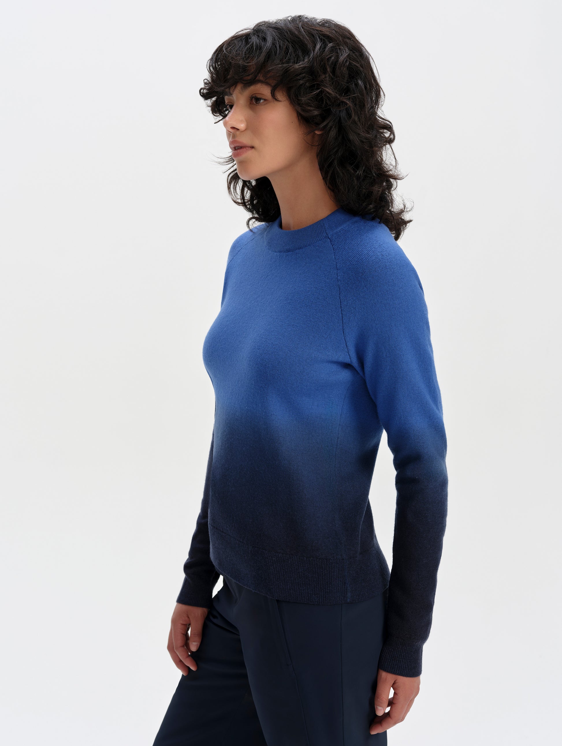 Front 3/4 upper-body view of woman wearing the Dash Ombre Sweater in Galaxy Blue from AETHER Apparel.
