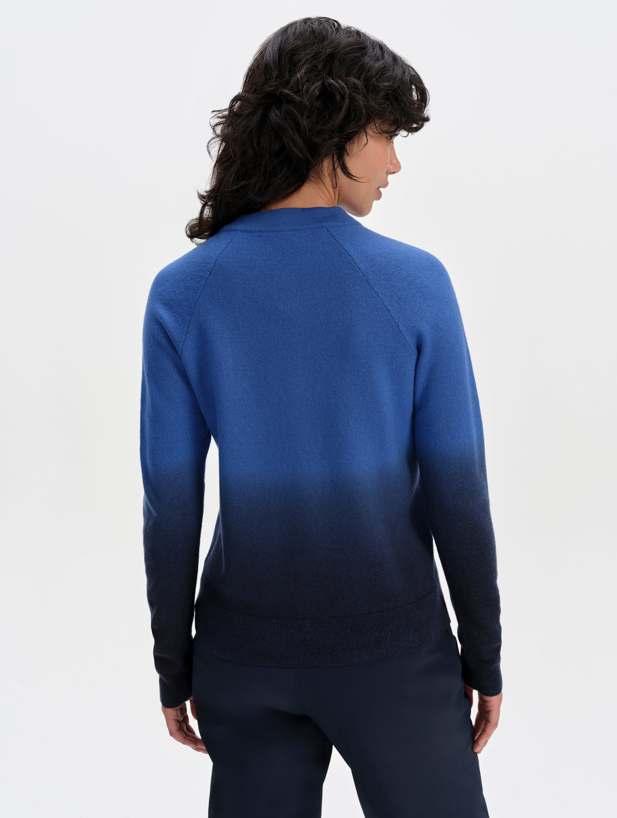 Rear upper-body view of woman wearing the Dash Ombre Sweater in Galaxy Blue from AETHER Apparel.