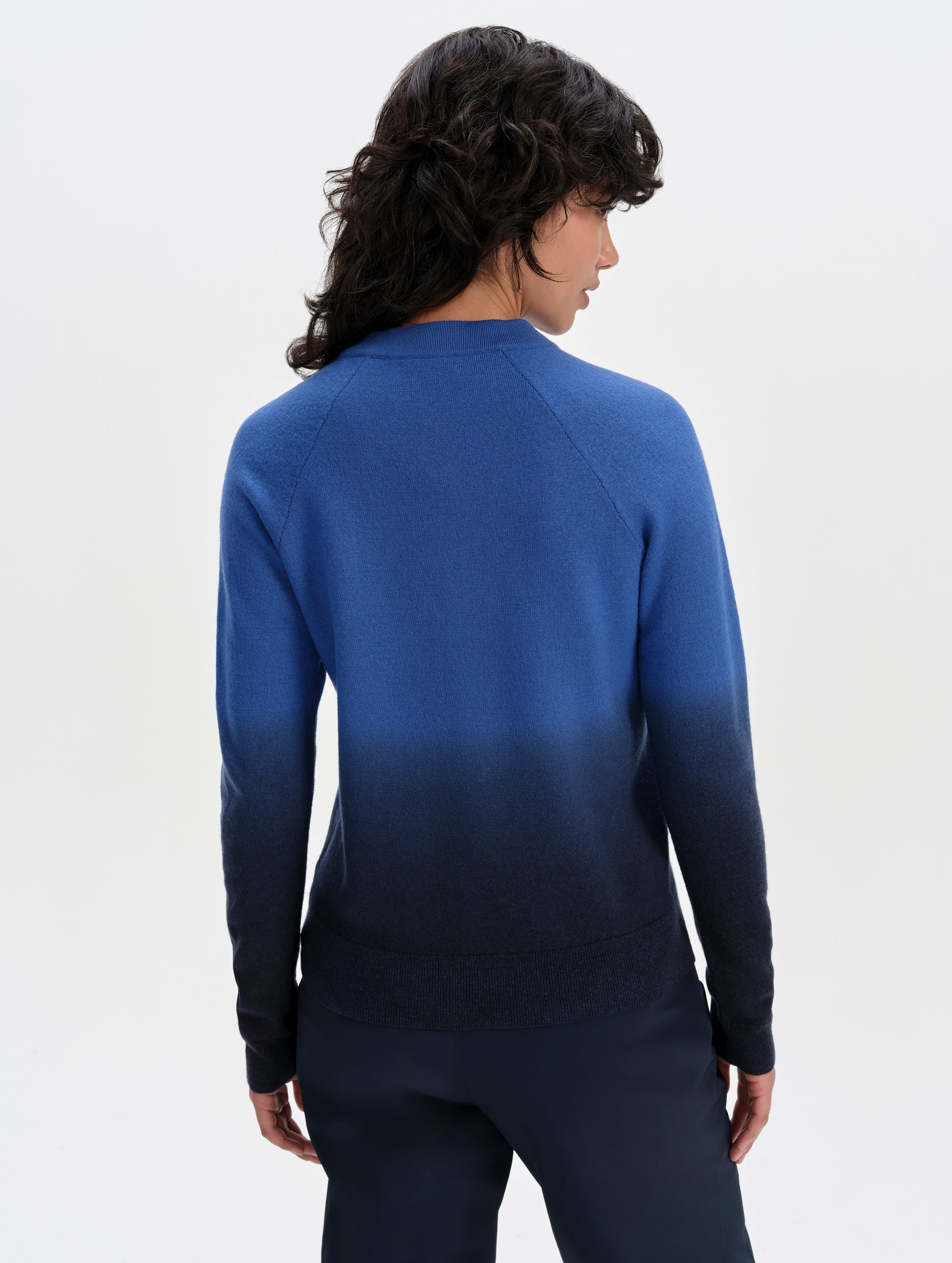 Rear upper-body view of woman wearing the Dash Ombre Sweater in Galaxy Blue from AETHER Apparel.