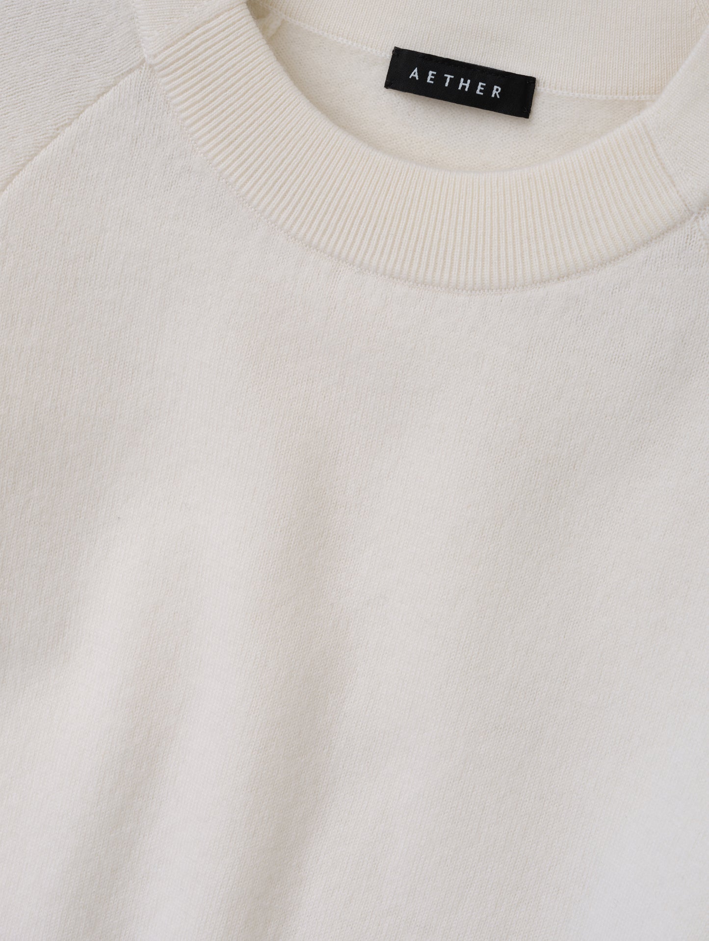 Closeup detailed view of the pieced in collar with rib knit front on the Dash Ombre Sweater in Winter White from AETHER Apparel.