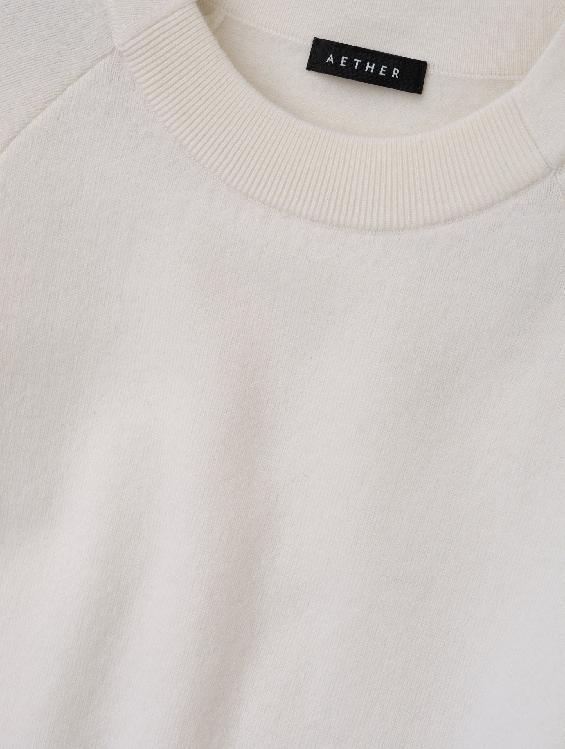 Closeup detailed view of the pieced in collar with rib knit front on the Dash Ombre Sweater in Winter White from AETHER Apparel.