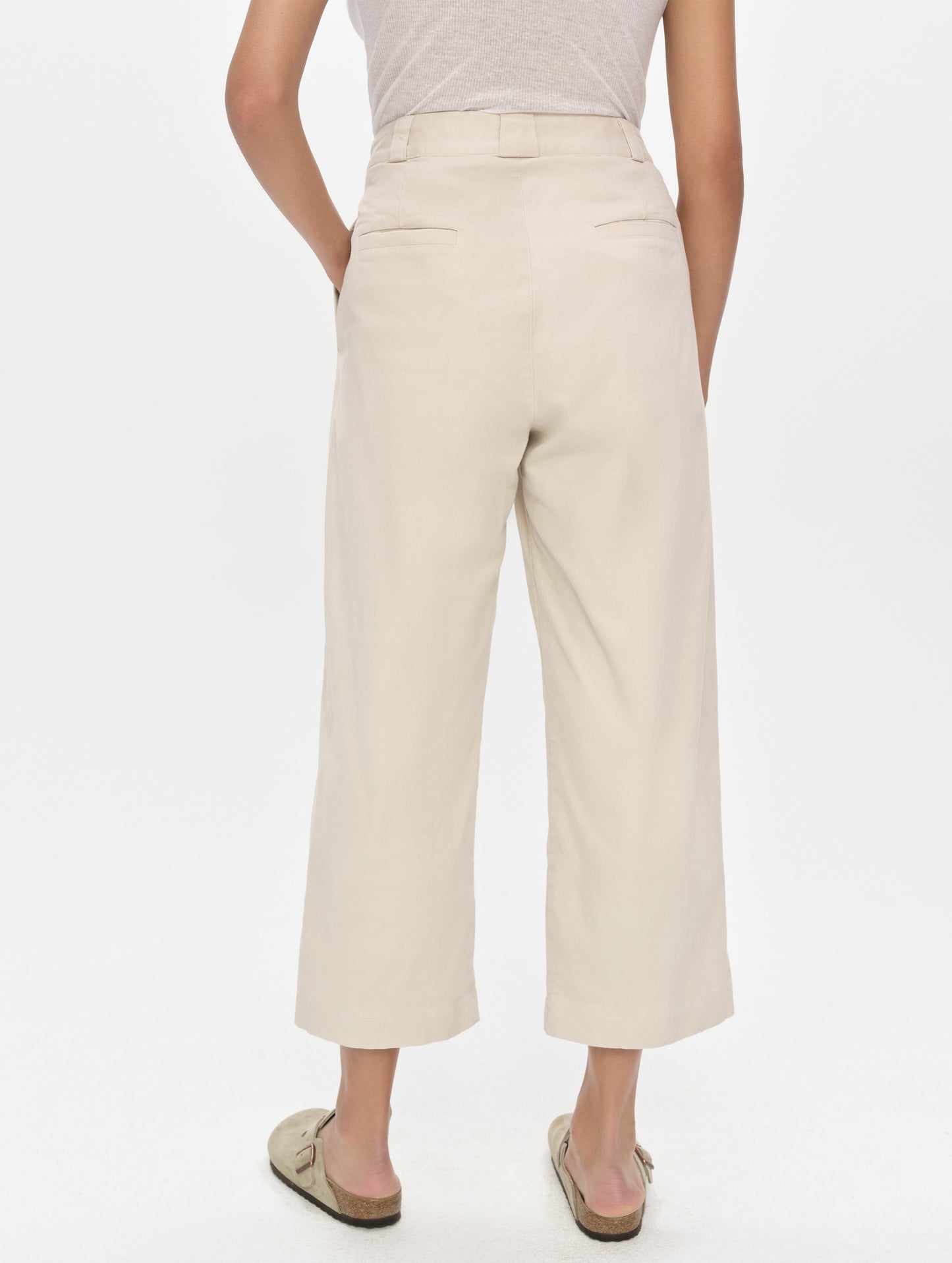 Rear, lower-body view of woman wearing the Dune Pant in Bone from AETHER Apparel.