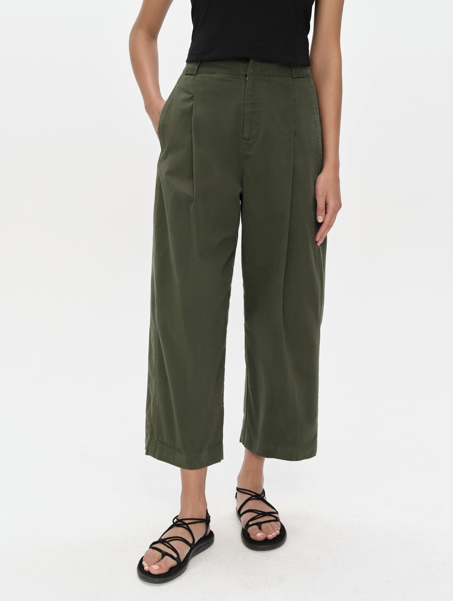 Front, lower-body view of woman wearing the Dune Pant in Forest Green from AETHER Apparel.