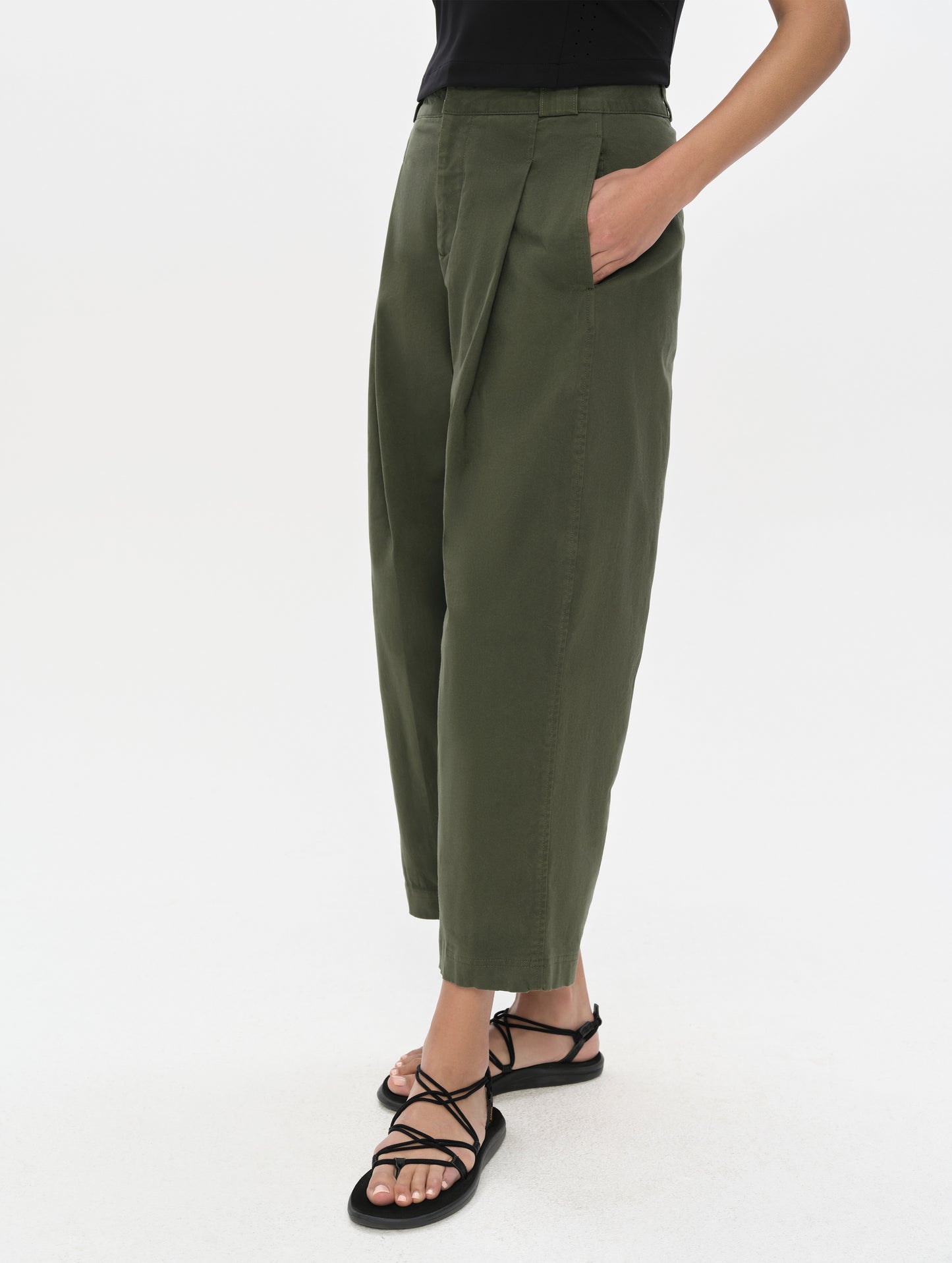 Front, 3/4, lower-body view of woman wearing the Dune Pant in Forest Green from AETHER Apparel.