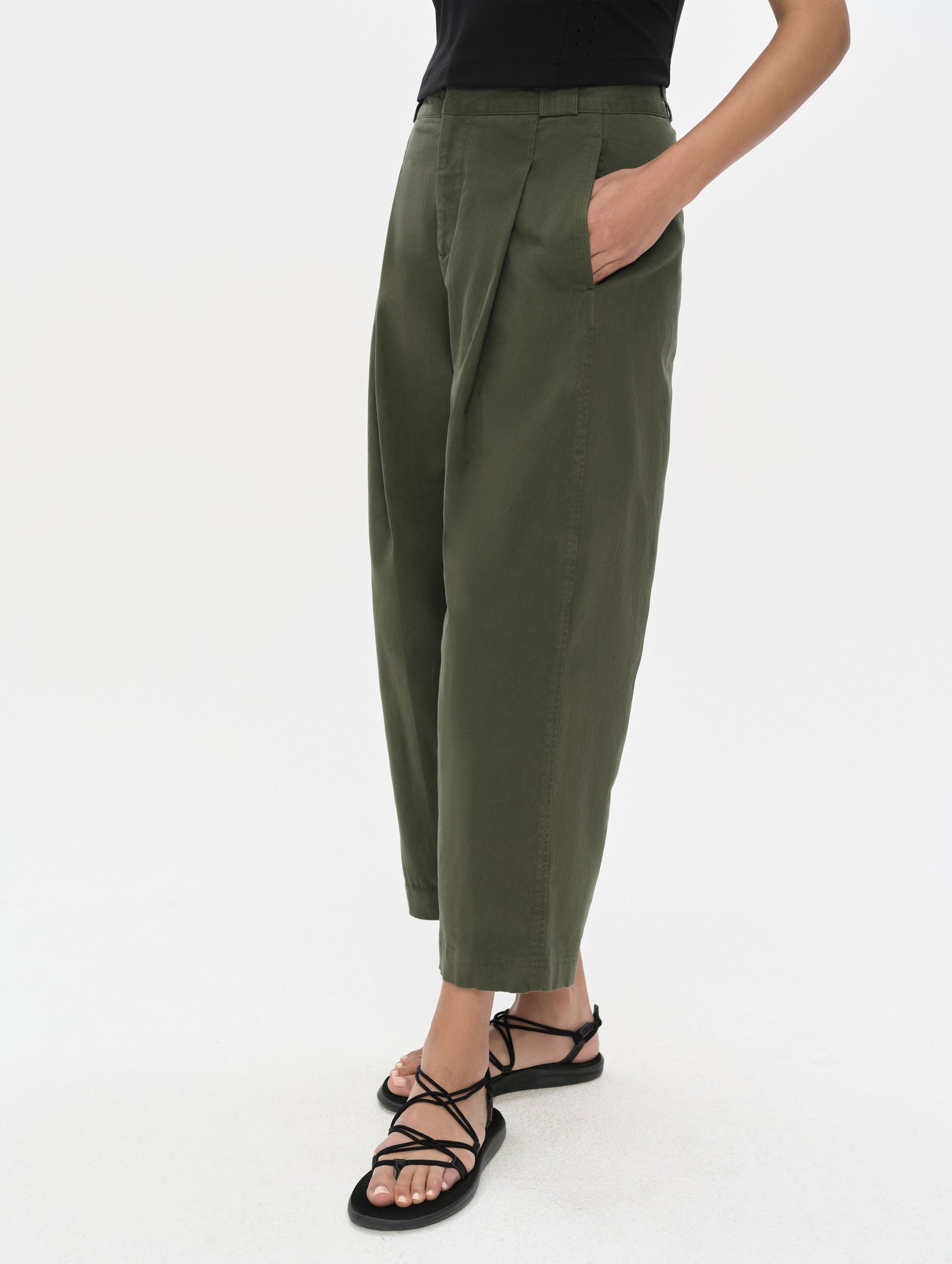 Front, 3/4, lower-body view of woman wearing the Dune Pant in Forest Green from AETHER Apparel.