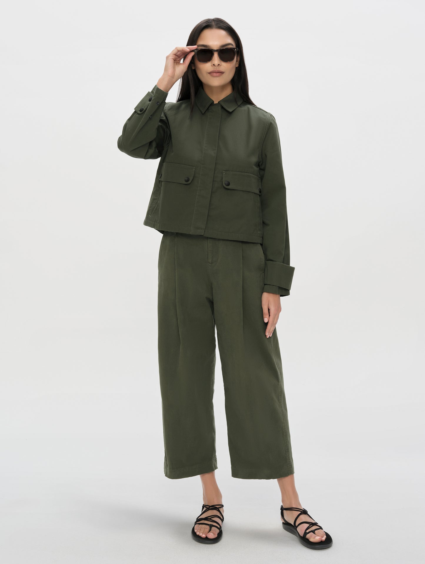 Front, full-body view of woman wearing the Dune Pant in Forest Green from AETHER Apparel.