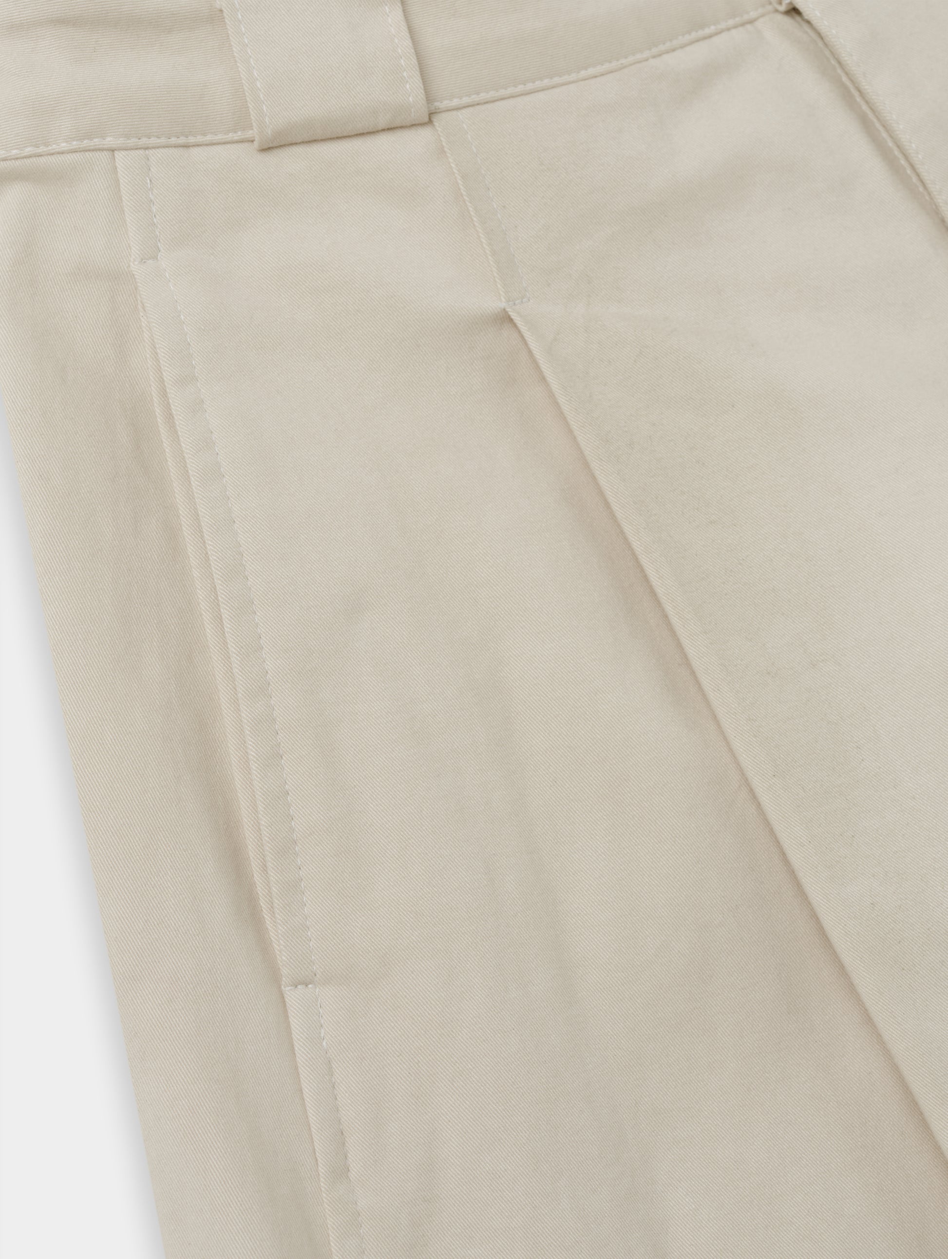 Closeup detailed view of the hand pockets and pleats on the Dune Short in Bone from AETHER Apparel.