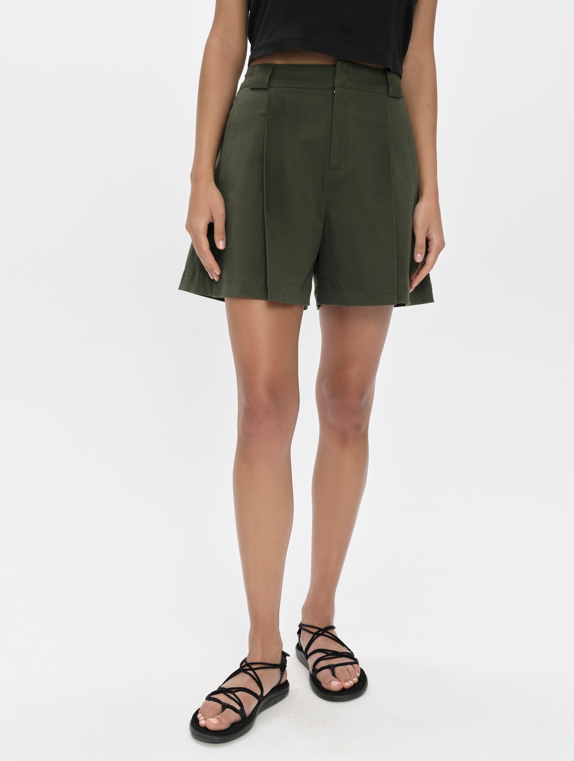 Front, lower-body view of woman wearing the Dune Short in Forest Green from AETHER Apparel.