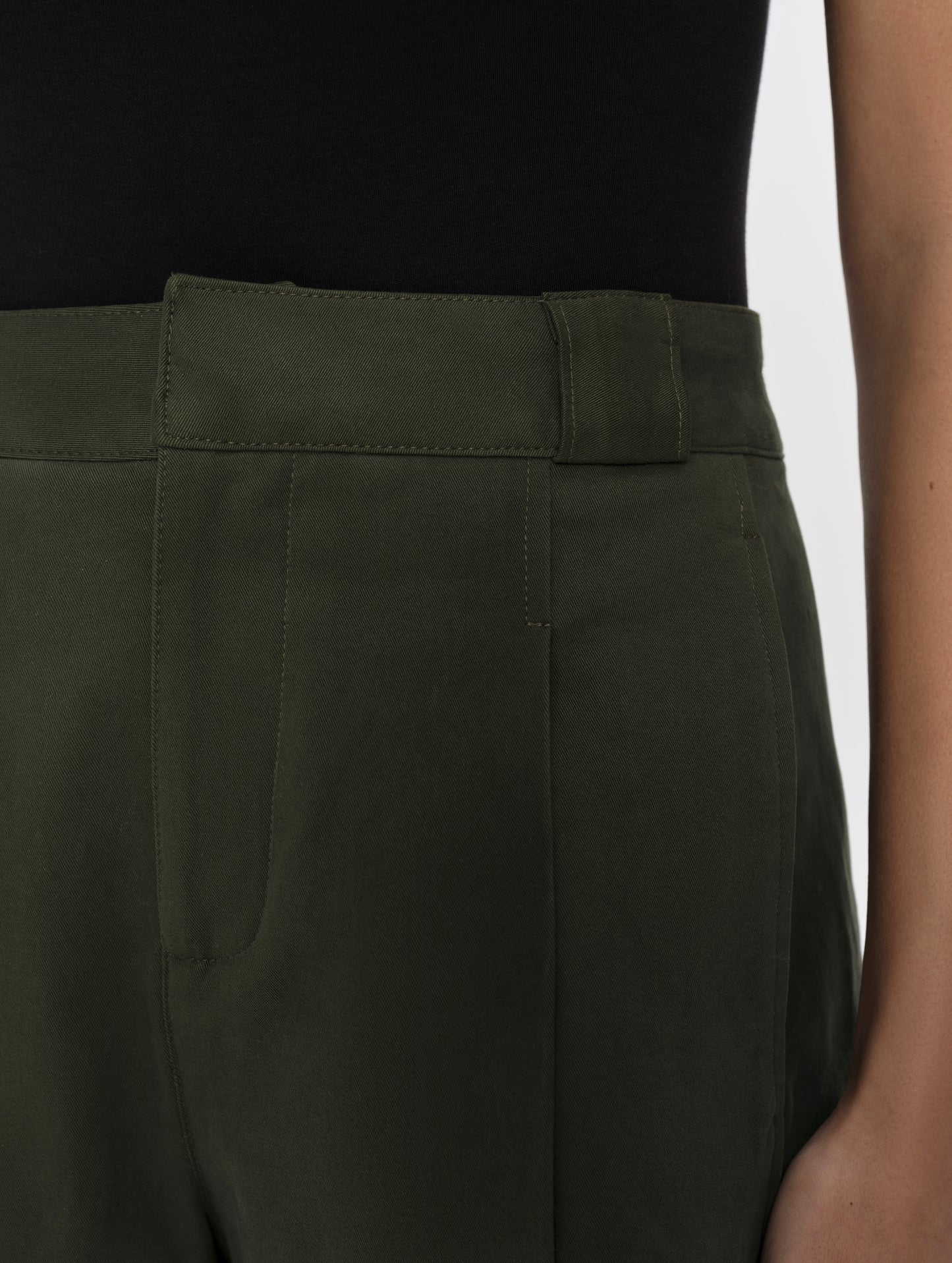Closeup detailed view of the front closure, waistband, and belt loops on the Dune Short in Forest Green from AETHER Apparel.