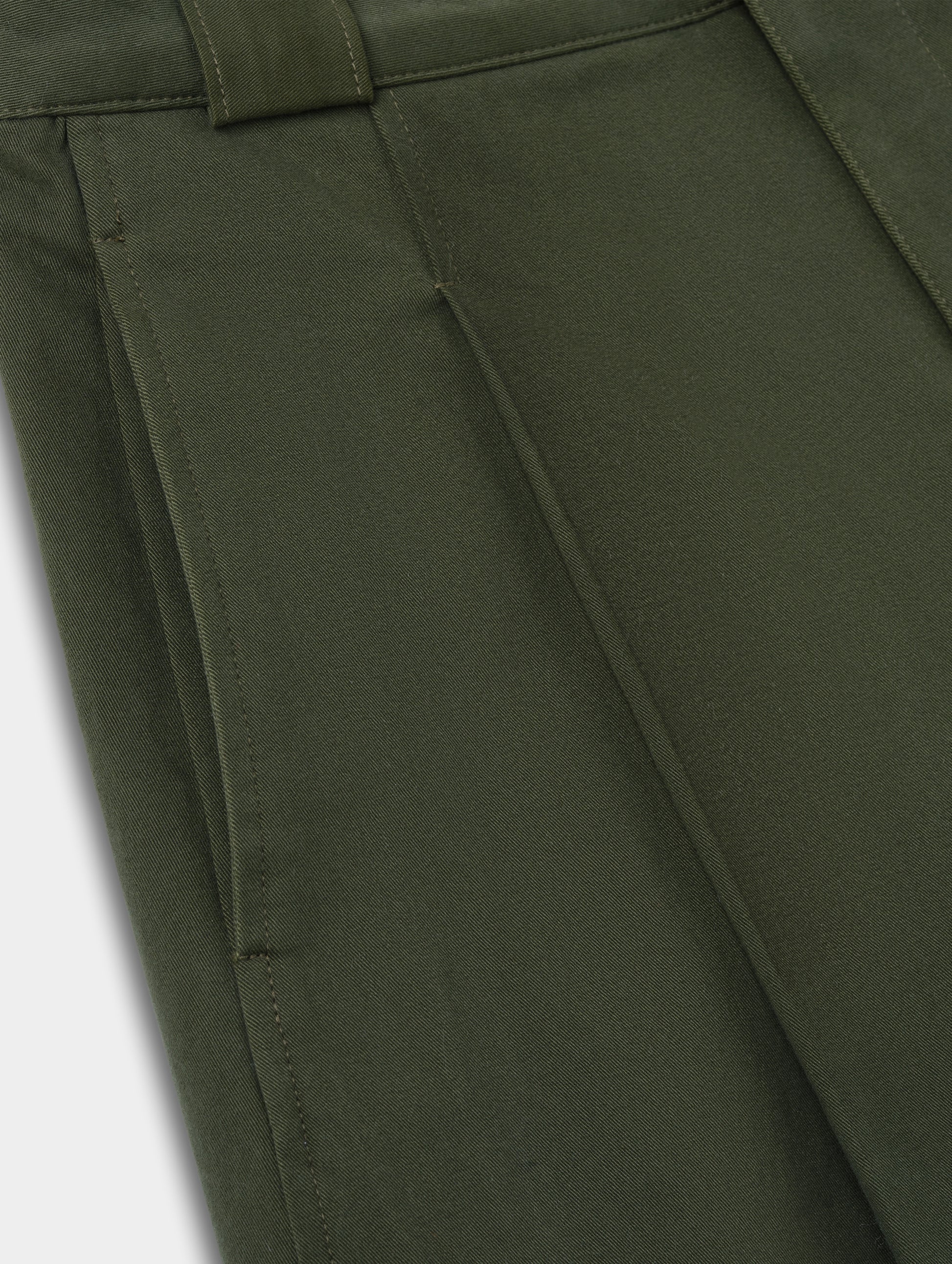 Closeup detailed view of the hand pockets and pleats on the Dune Short in Forest Green from AETHER Apparel.