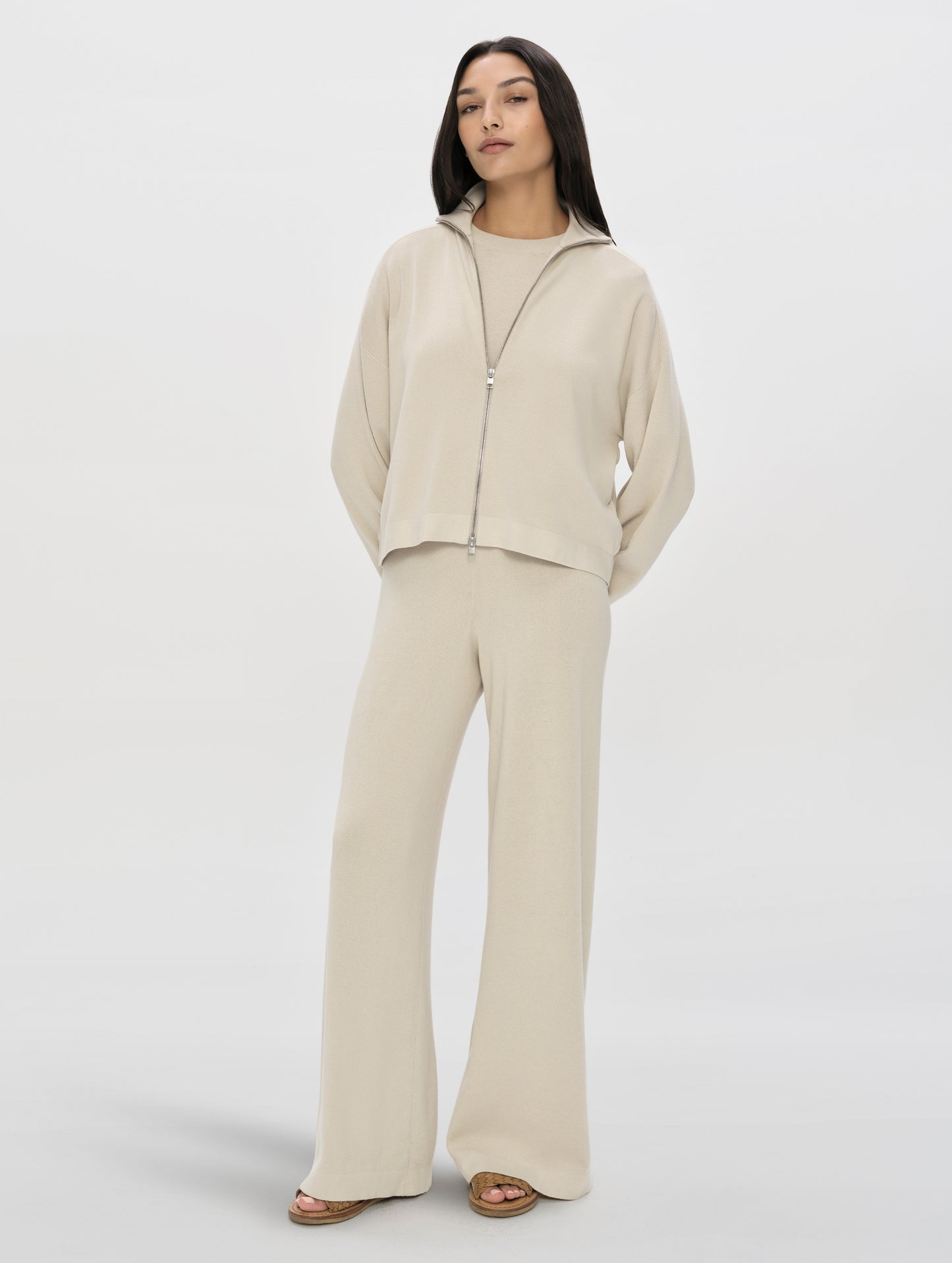 Front, full-body view of woman wearing the Eliana Full-ZIp Sweater in Bone from AETHER Apparel.