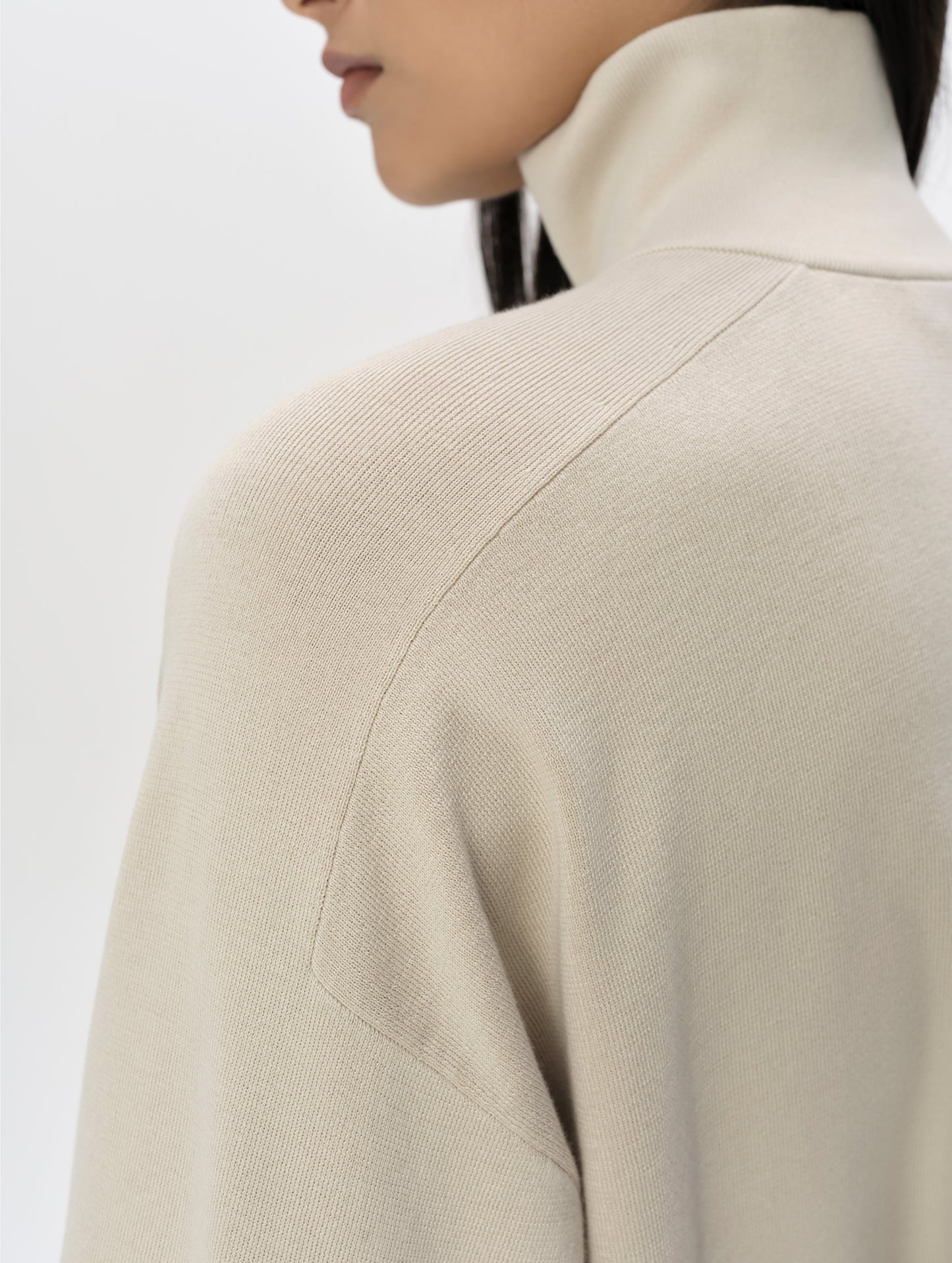 Closeup detailed view of the shoulder and collar on the Eliana Full-ZIp Sweater in Bone from AETHER Apparel.