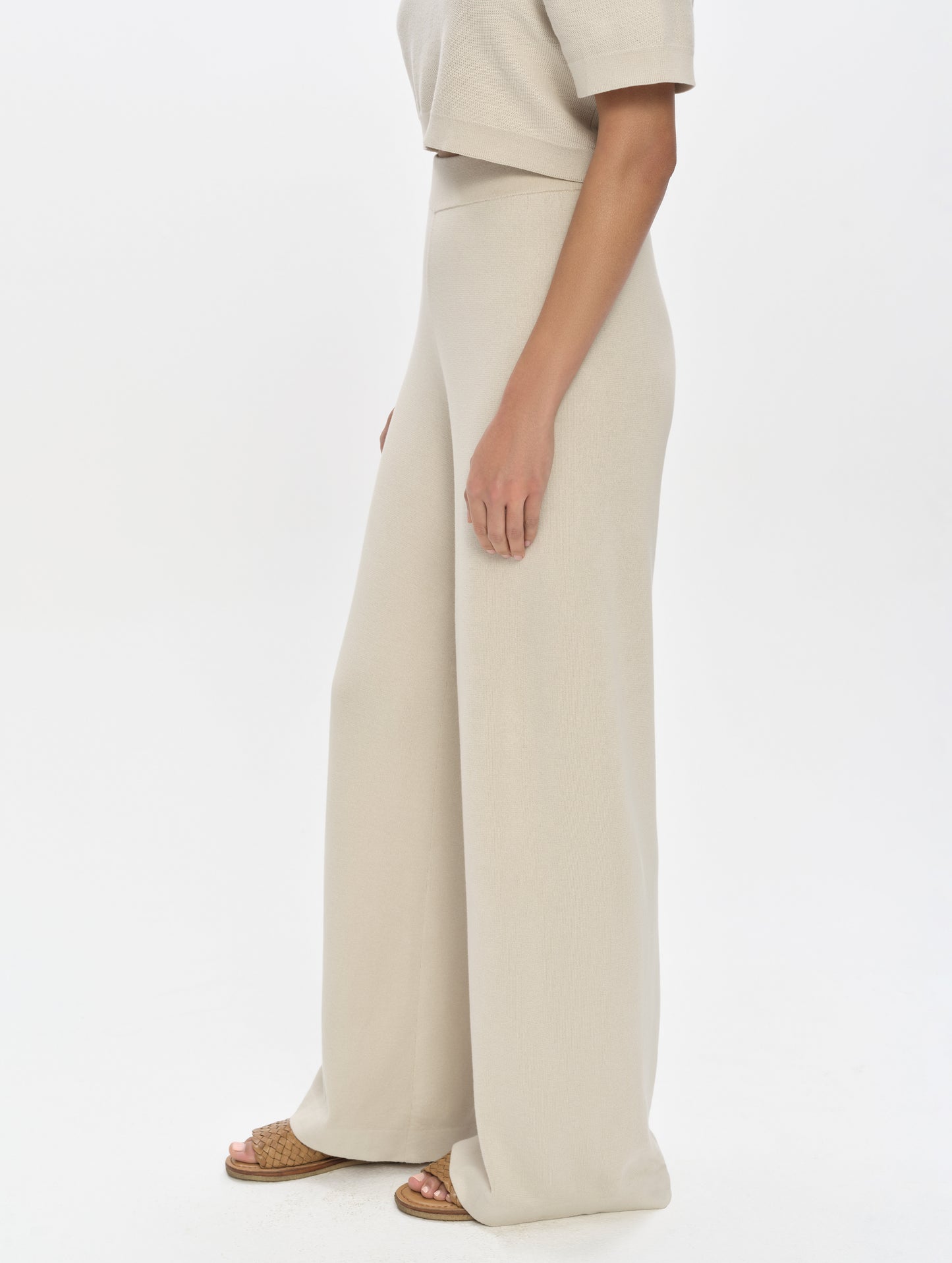 Side profile, lower-body view of woman wearing the Eliana Sweater Pant in Bone from AETHER Apparel.