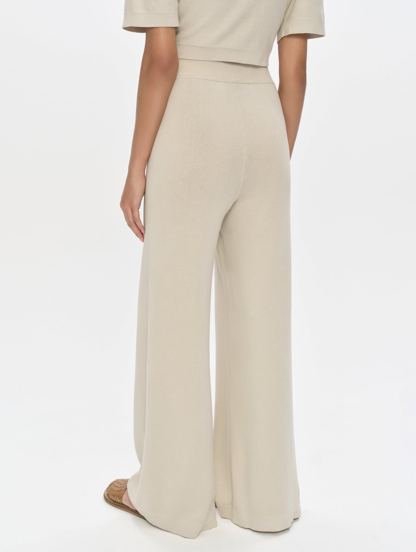 Rear, 3/4, lower-body view of woman wearing the Eliana Sweater Pant in Bone from AETHER Apparel.