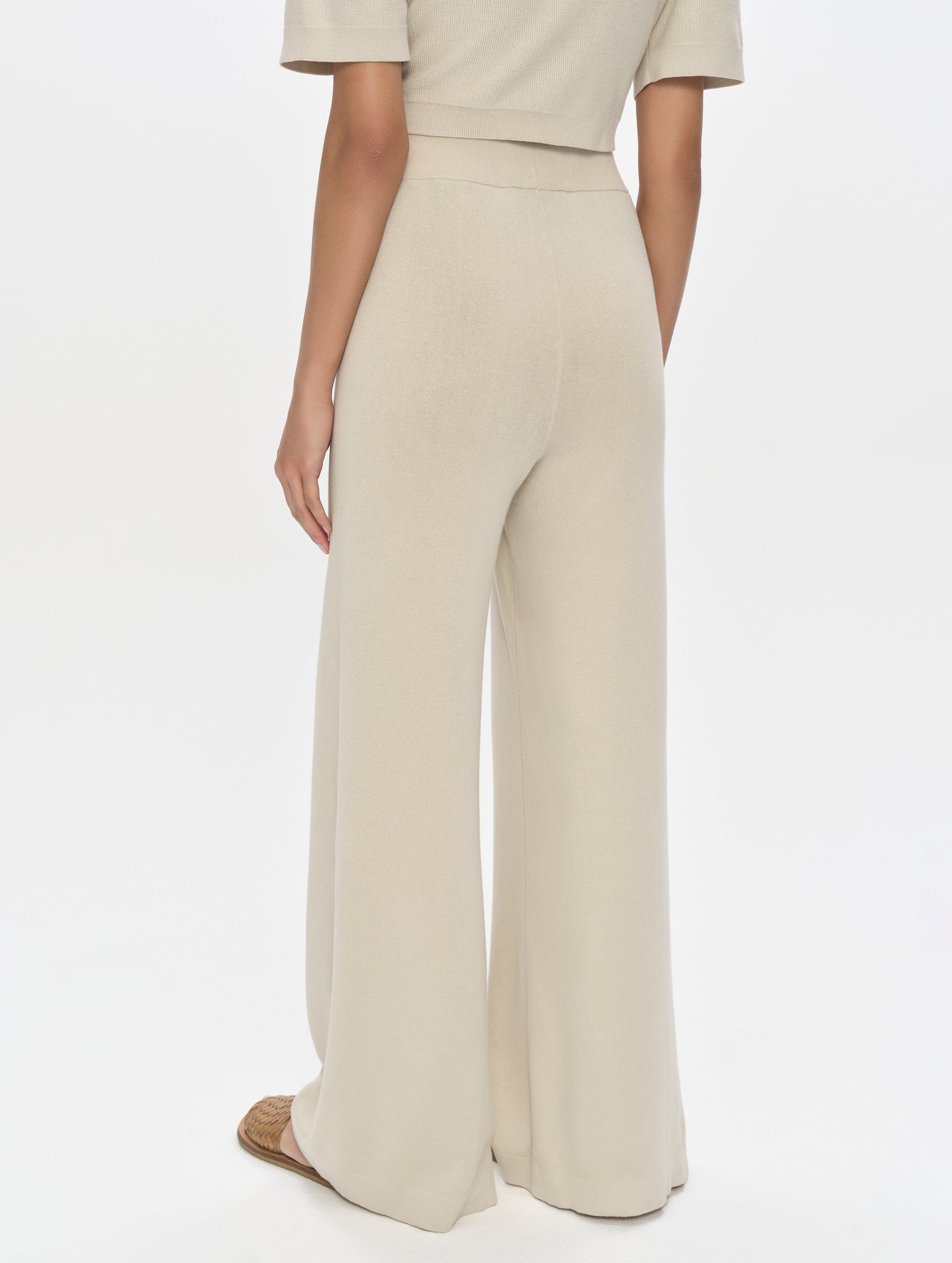 Rear, 3/4, lower-body view of woman wearing the Eliana Sweater Pant in Bone from AETHER Apparel.