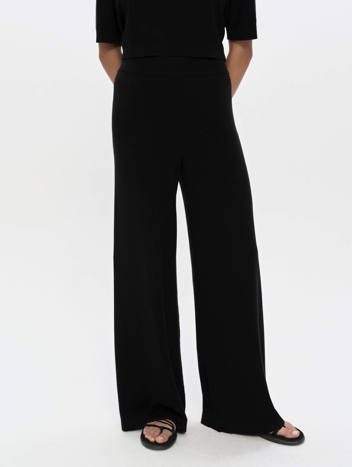 Front, lower-body view of woman wearing the Eliana Sweater Pant in Onyx Black from AETHER Apparel.