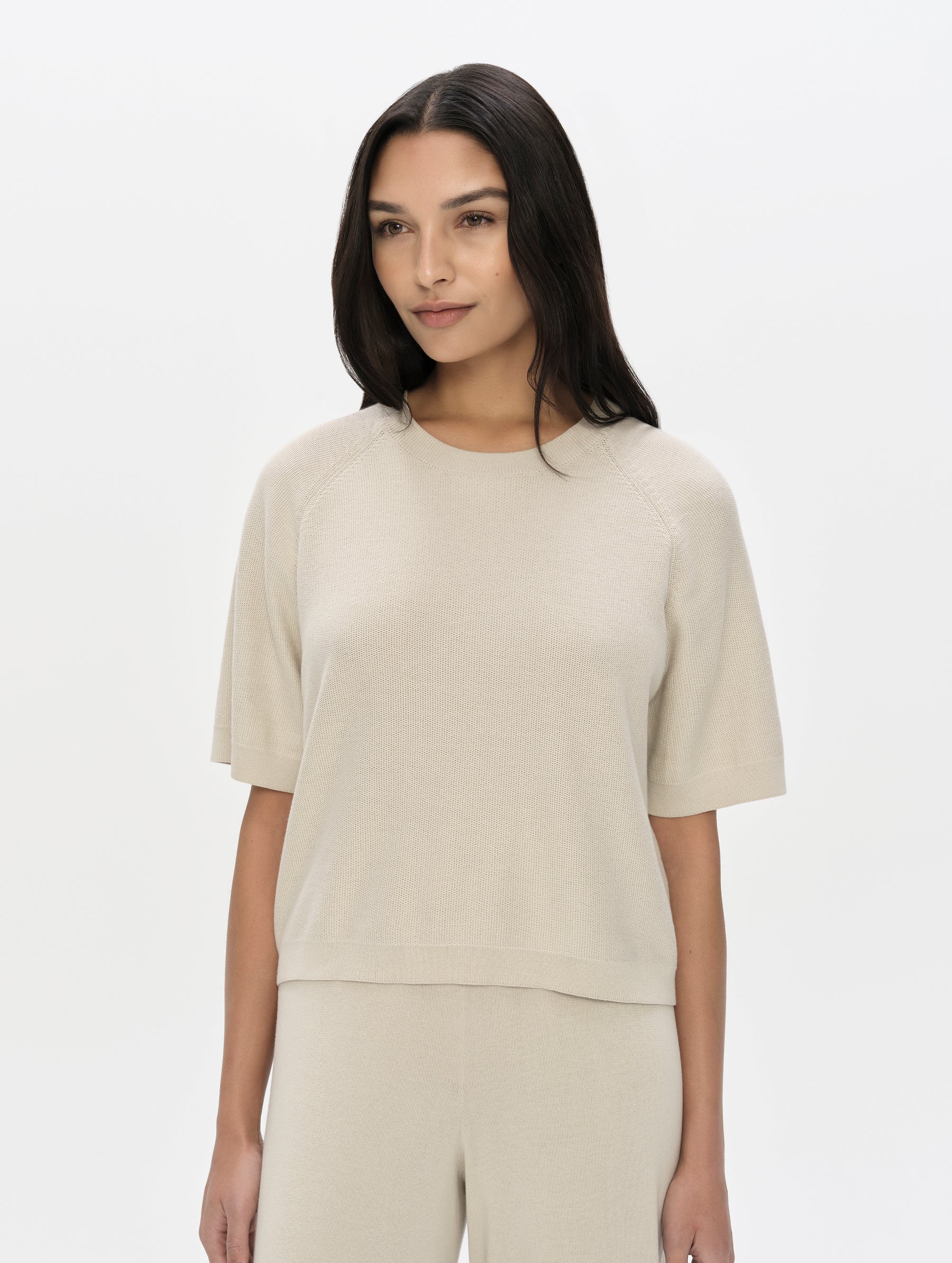 Front, upper-body view of woman wearing the Eliana Sweater Tee in Bone from AETHER Apparel.