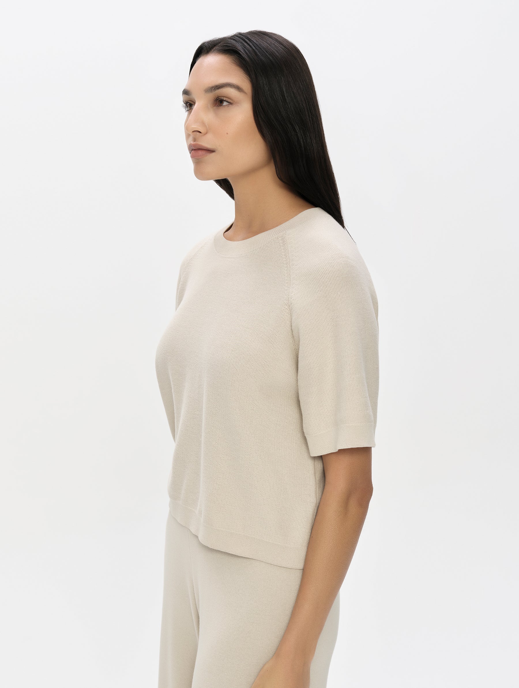 Front, 3/4, upper-body view of woman wearing the Eliana Sweater Tee in Bone from AETHER Apparel.