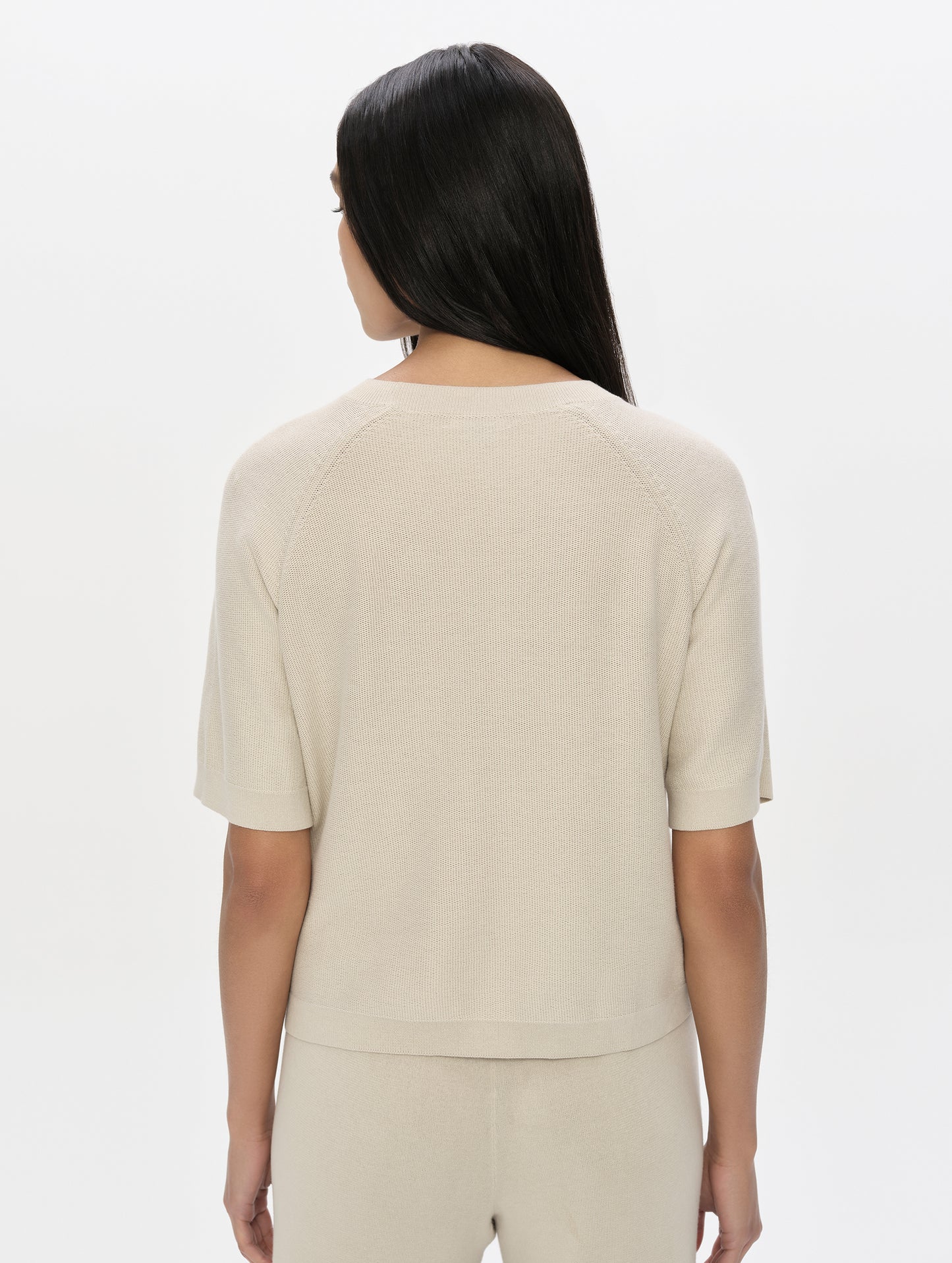 Rear, upper-body view of woman wearing the Eliana Sweater Tee in Bone from AETHER Apparel.
